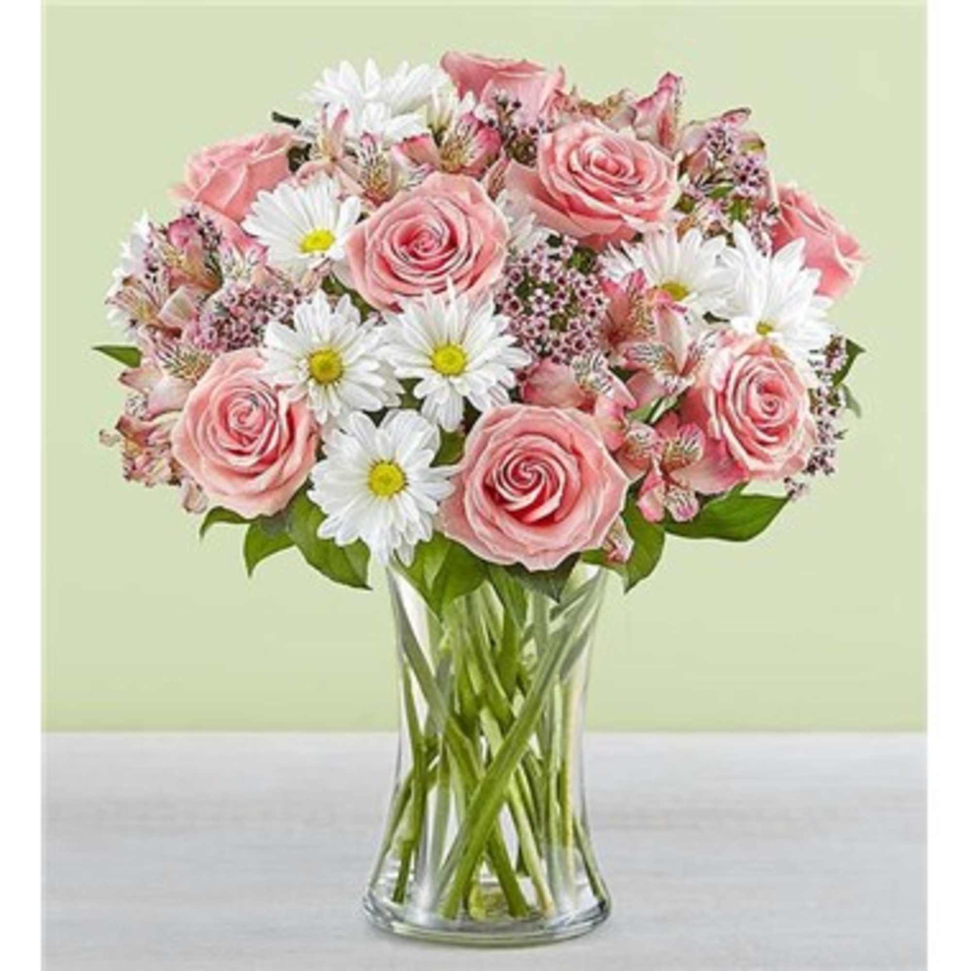 Pink roses and white daisies in a clear glass vase