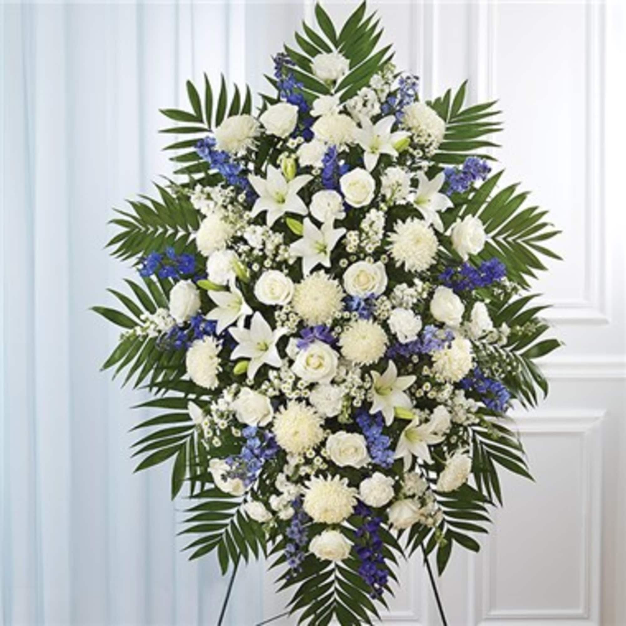 Standing funeral spray of white and blue flowers on an easel