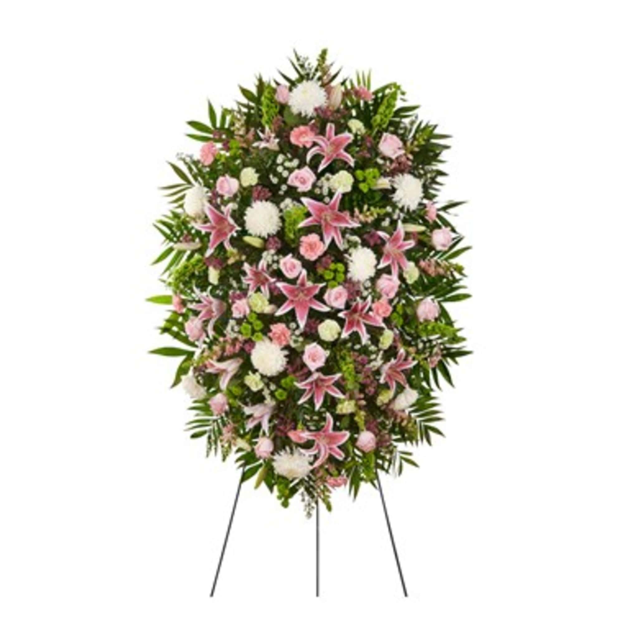 Standing funeral spray with pink lilies and mixed white flowers on an easel