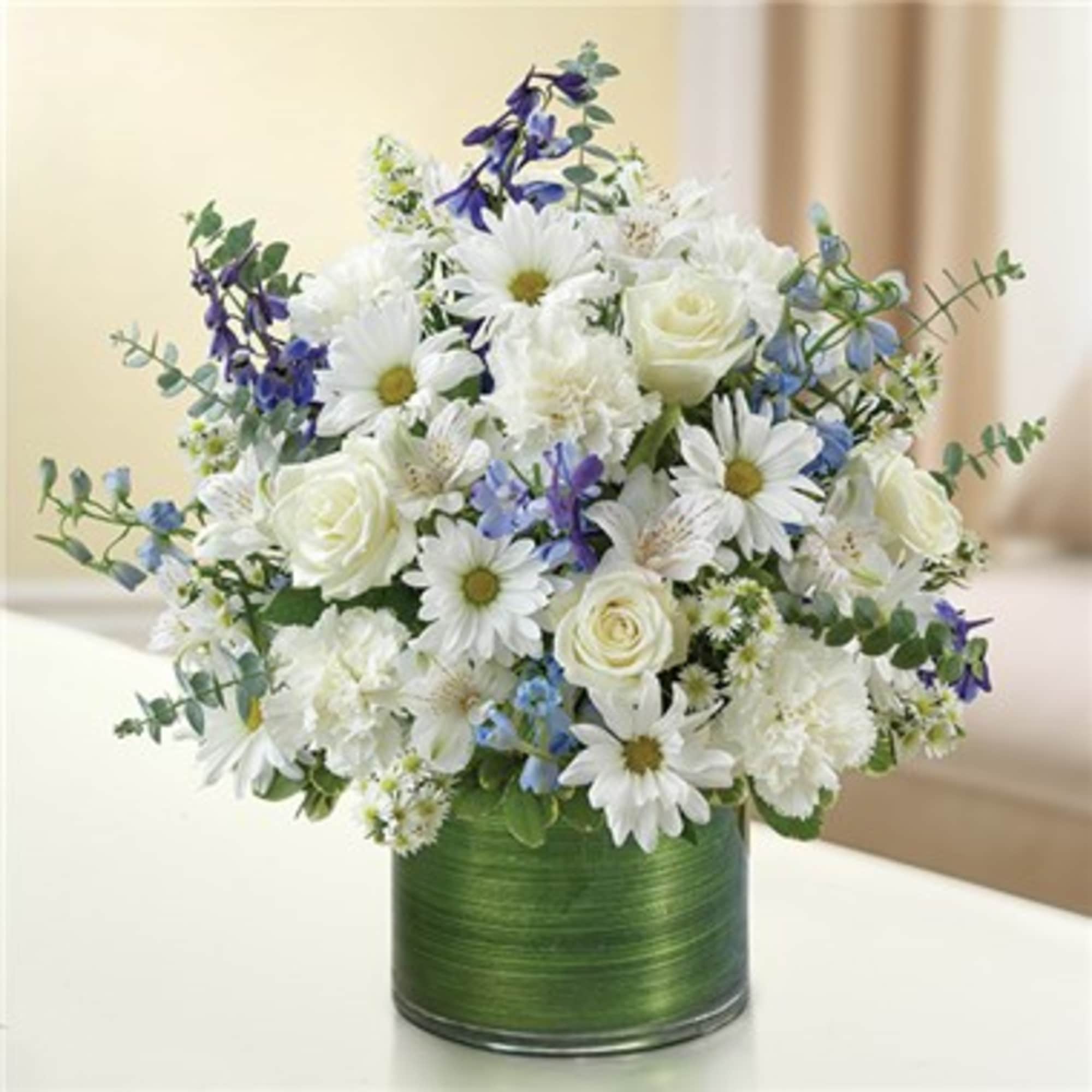 White daisies and roses in a green cylindrical vase