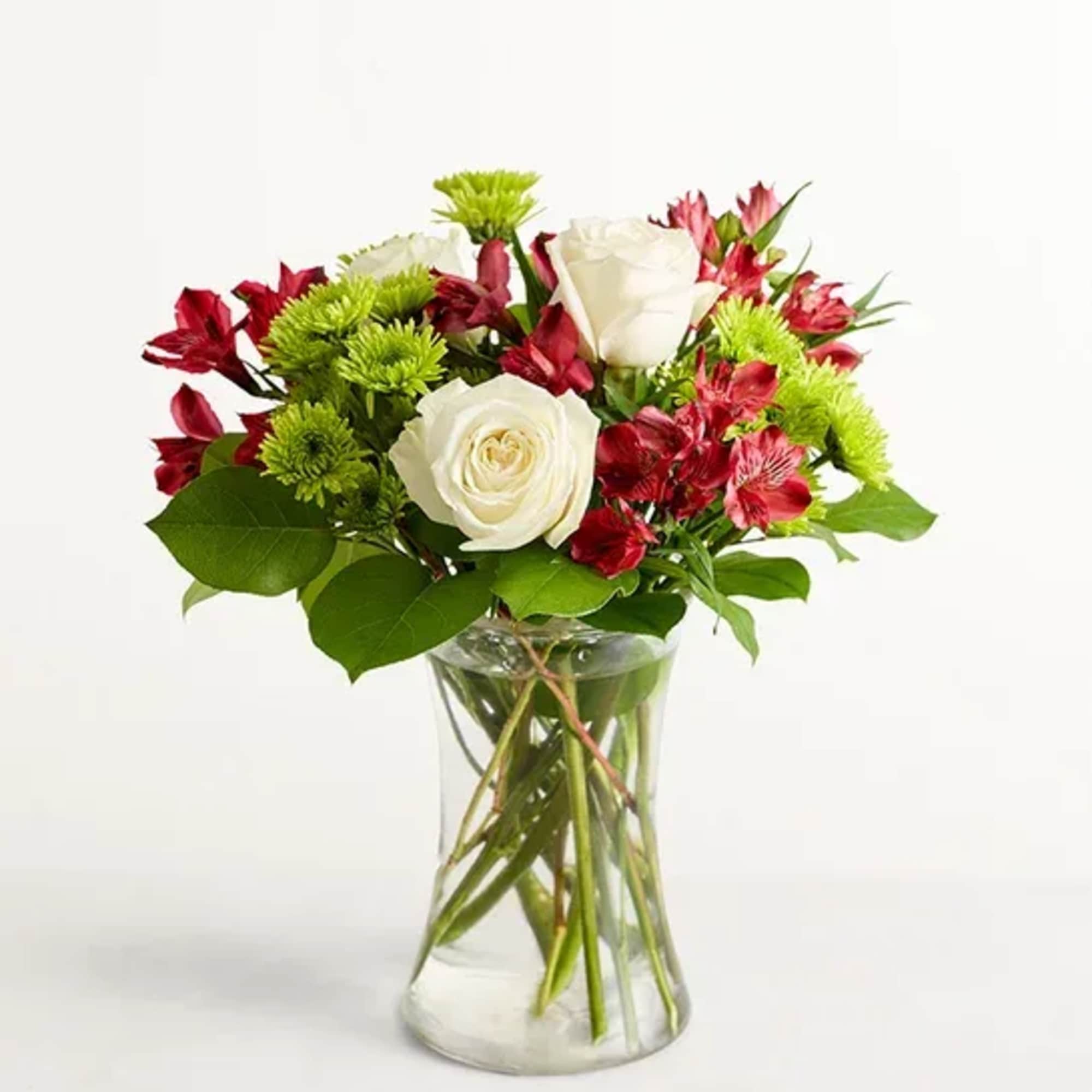 White roses and red alstroemeria in a clear glass vase