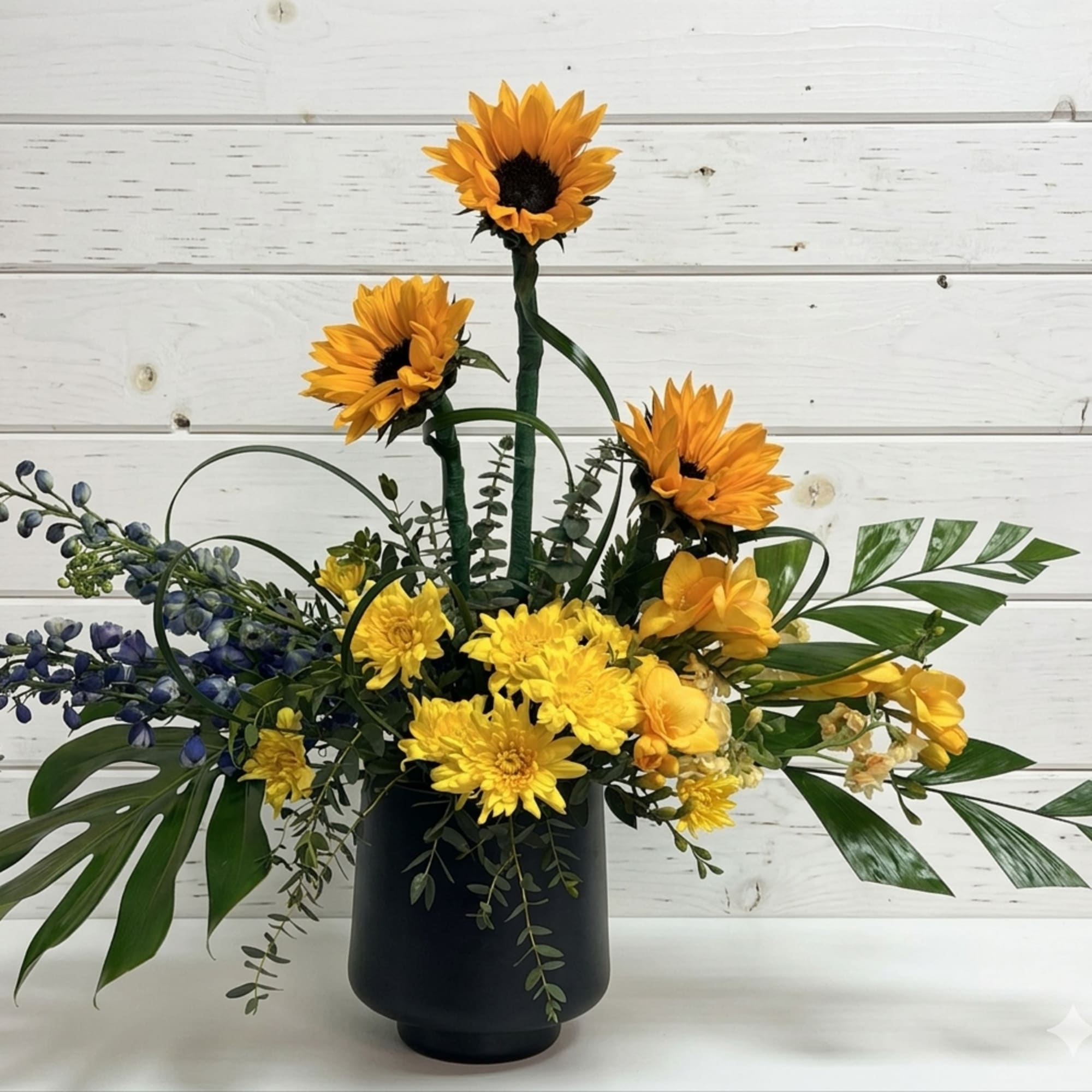 Bring a burst of sunshine indoors with this cheerful garden-inspired arrangement. Featuring