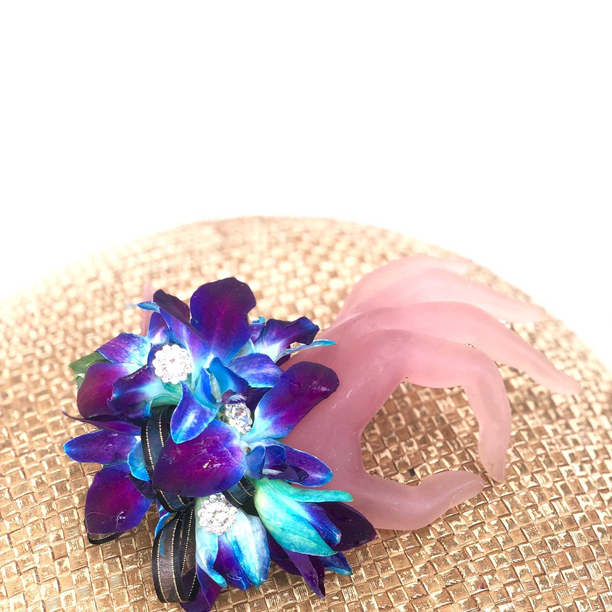 Blue-purple floral boutonniere with a pink wrist cuff