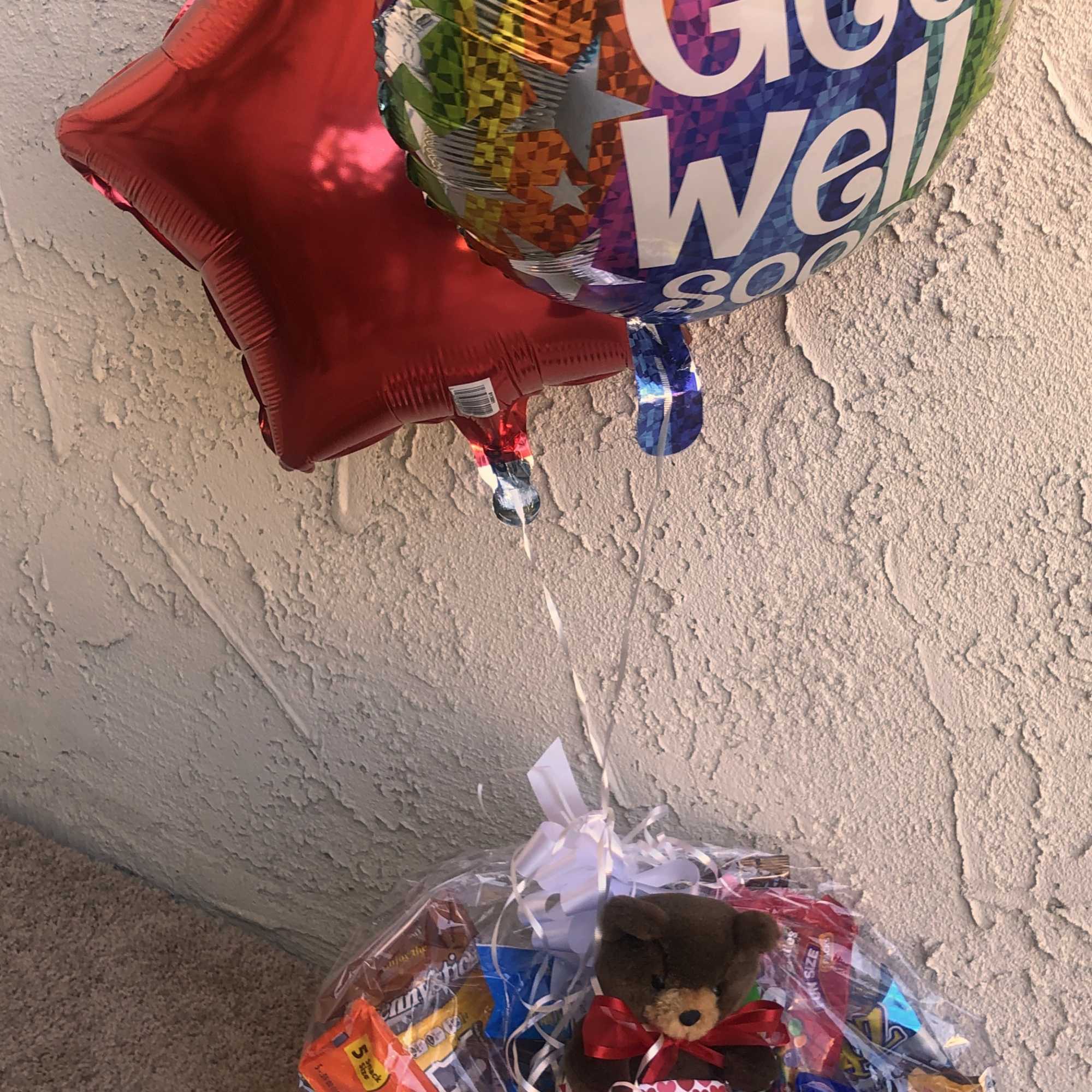 Gift basket with candy, a teddy bear, and two balloons
