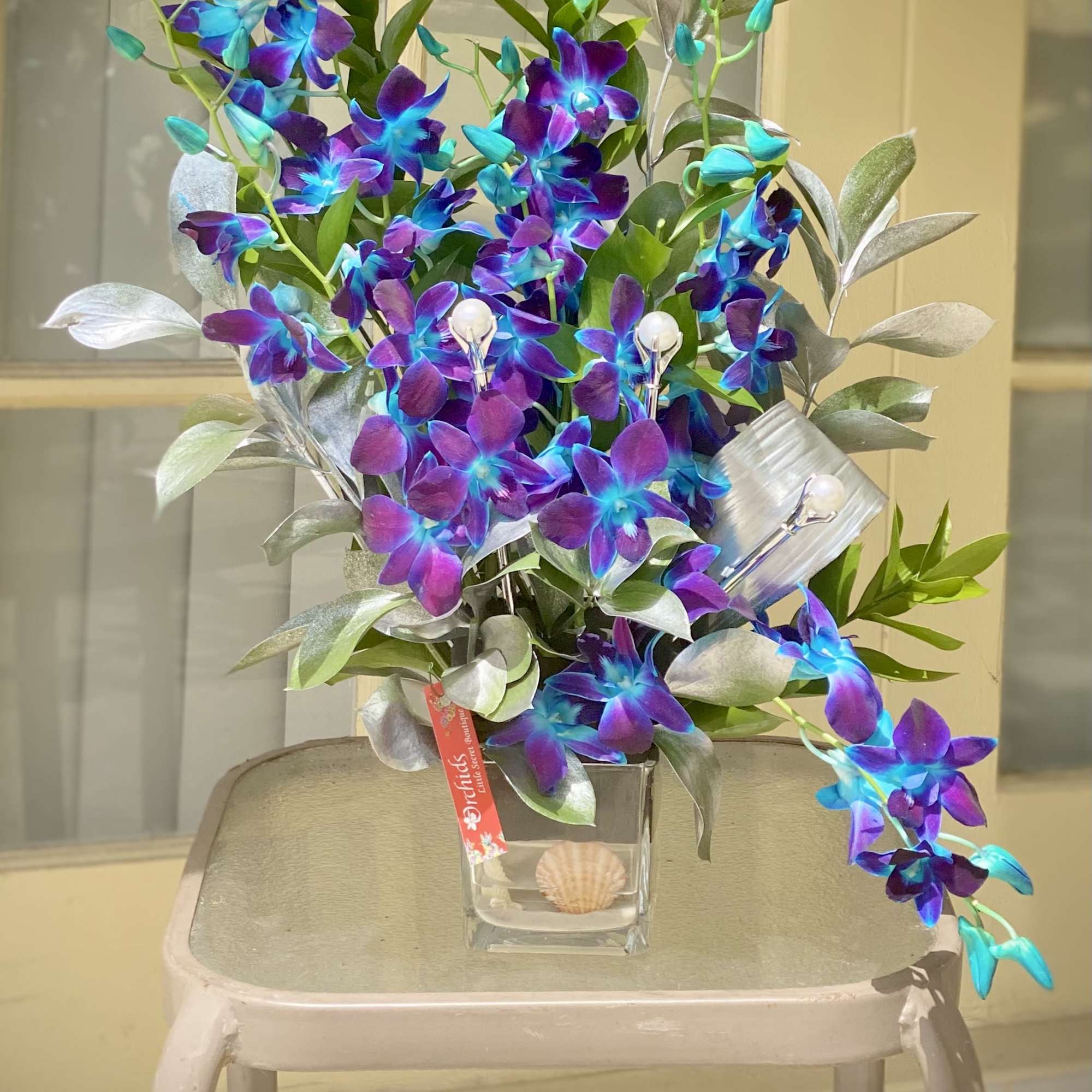 Purple and blue orchids arranged in a clear glass vase