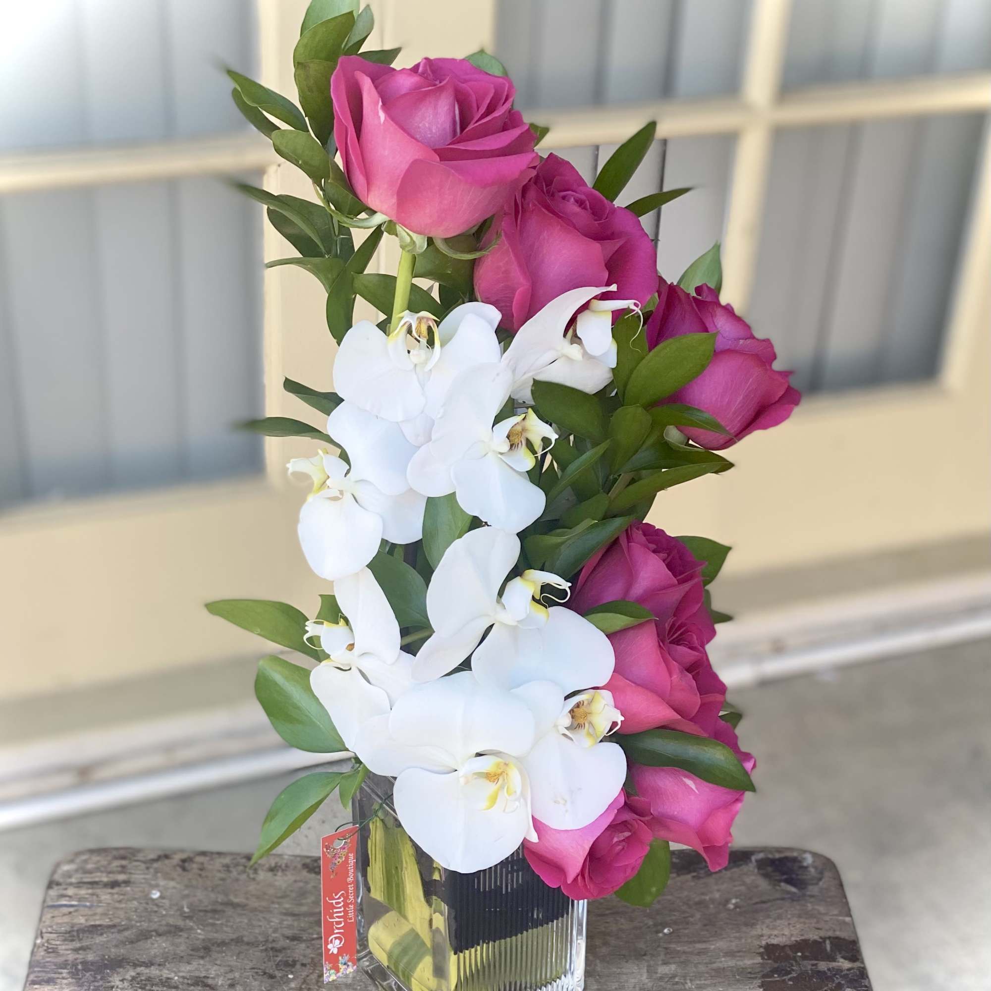 Pink roses and white orchids in a clear glass vase