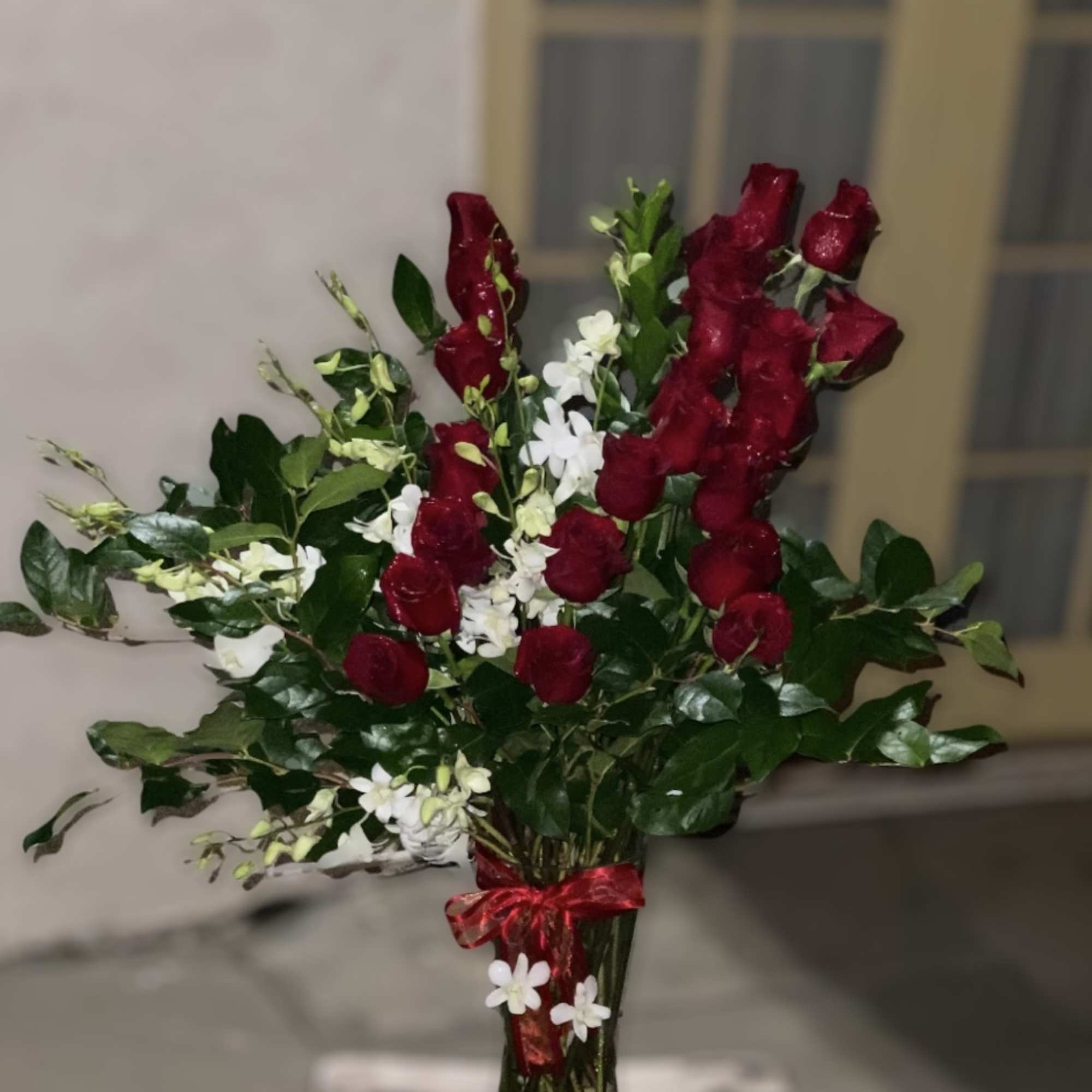 Bouquet of red roses and white flowers in a glass vase