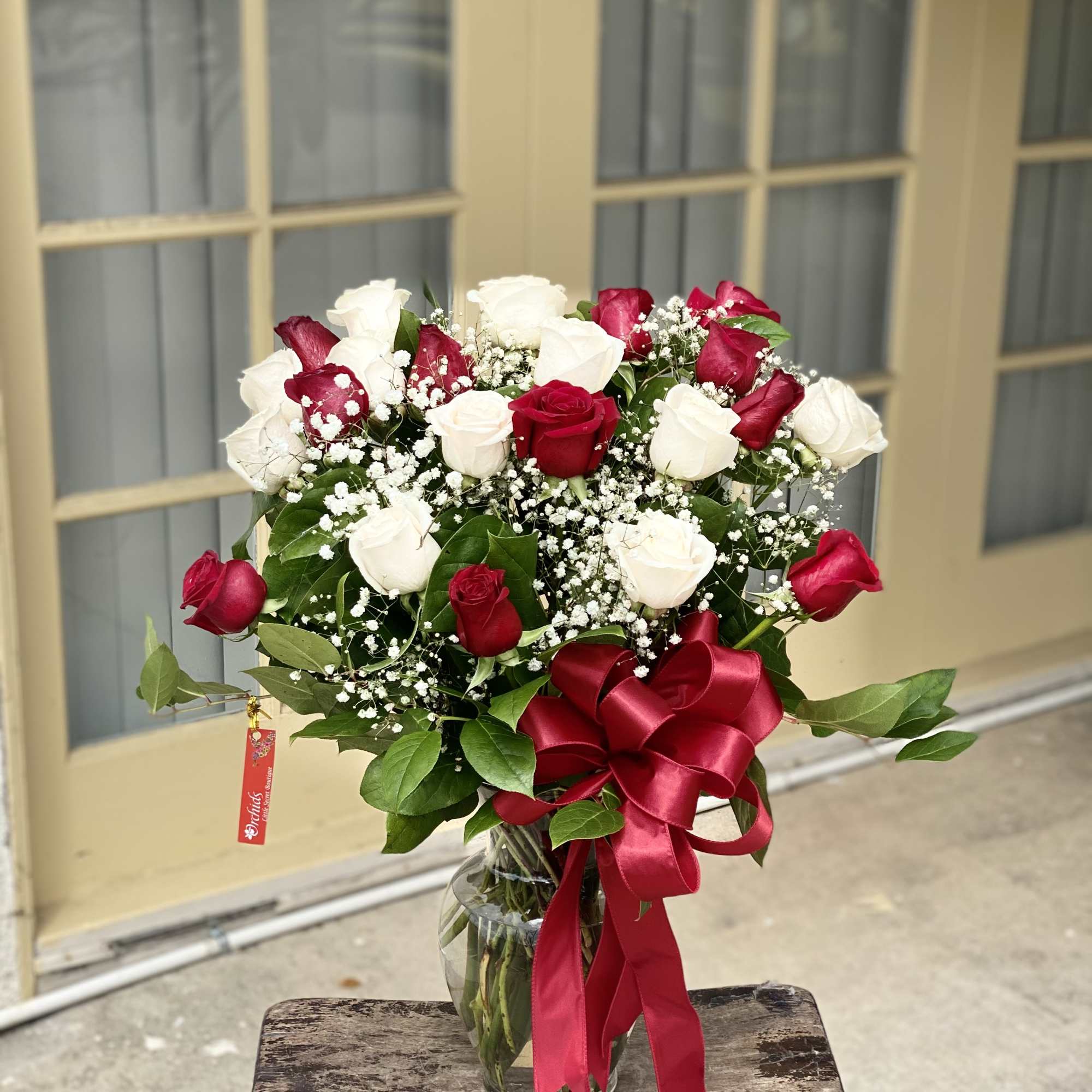 Bouquet of red and white roses in a glass vase with a red ribbon, photo 2 of 2