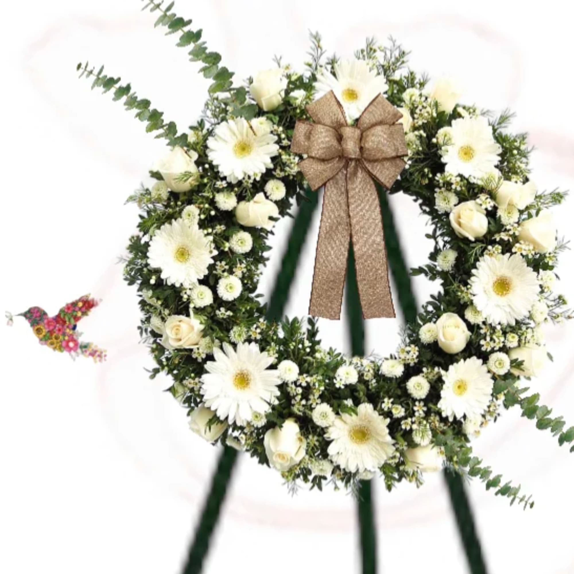 White floral wreath with a brown bow on a stand