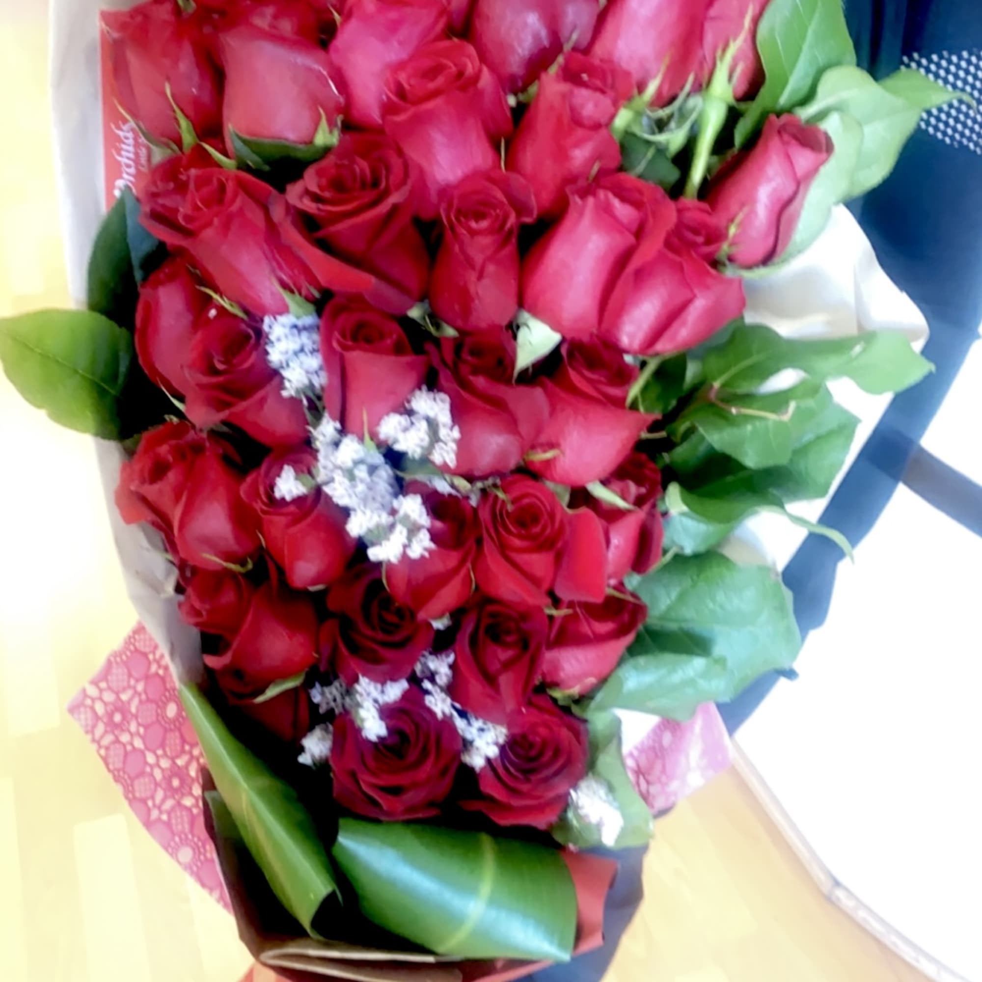Large bouquet of red roses with small white filler flowers