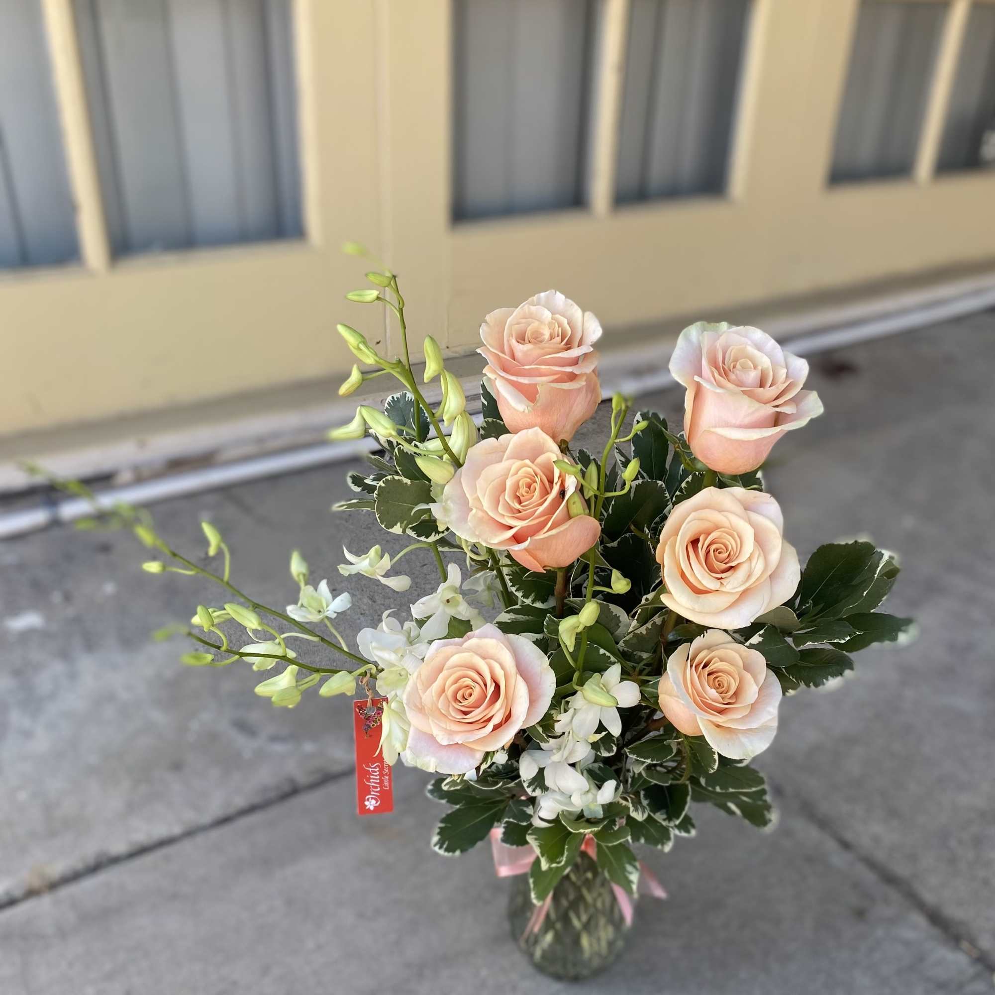 Peach roses with white orchids in a glass vase, photo 2 of 2