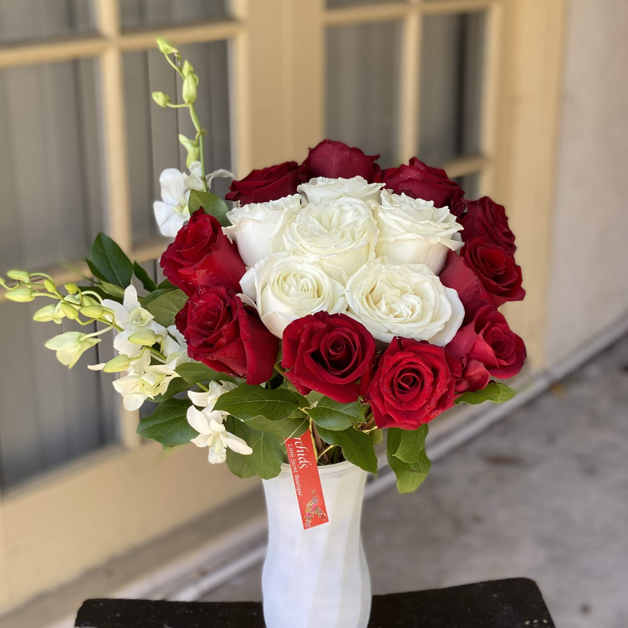 Red and white roses arranged in a white vase, photo 2 of 2