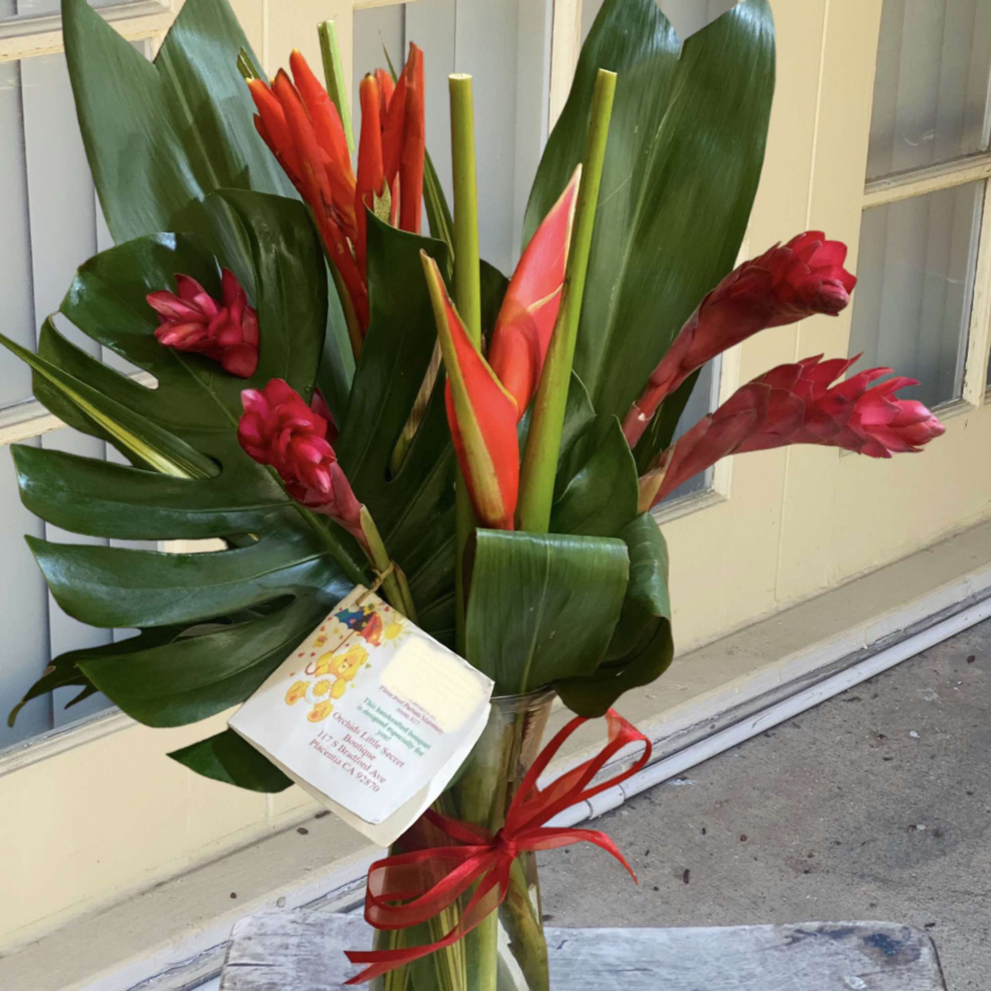 Tropical bouquet with red ginger flowers in a glass vase