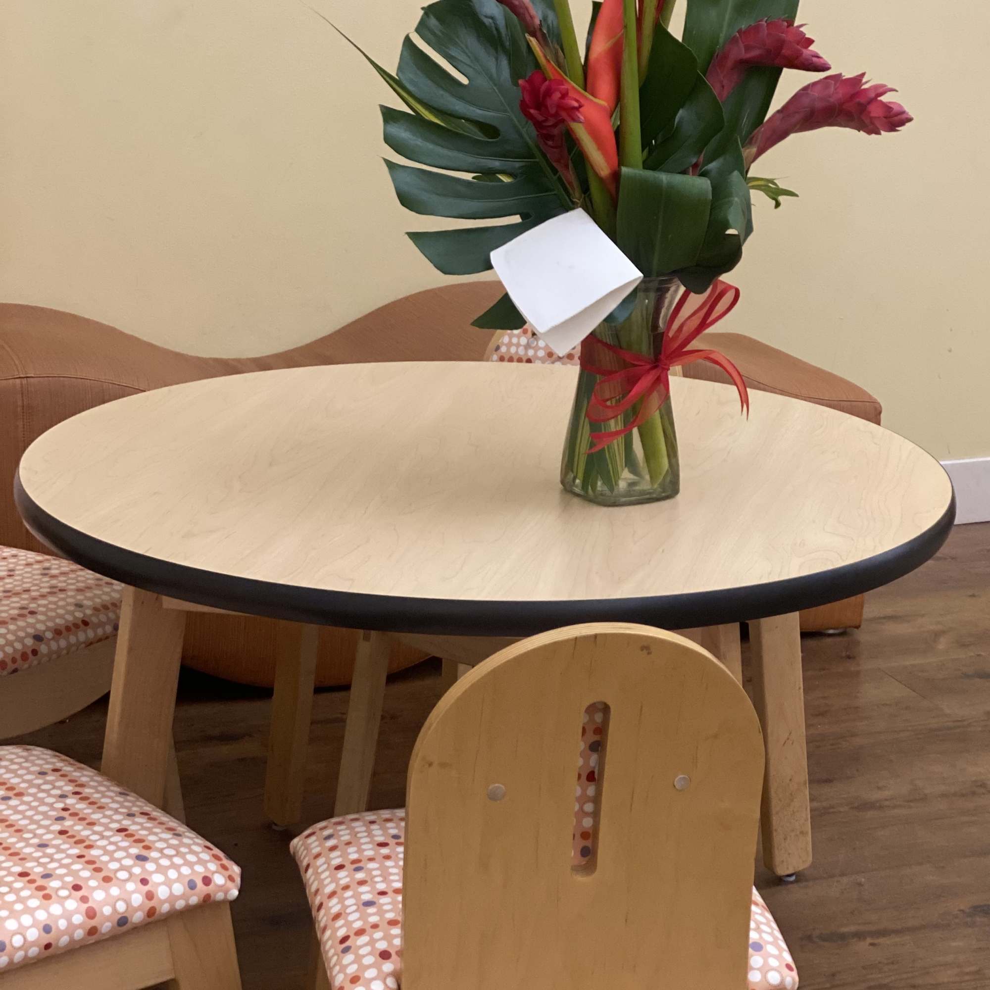 Tropical flower arrangement in a glass vase with red ribbon