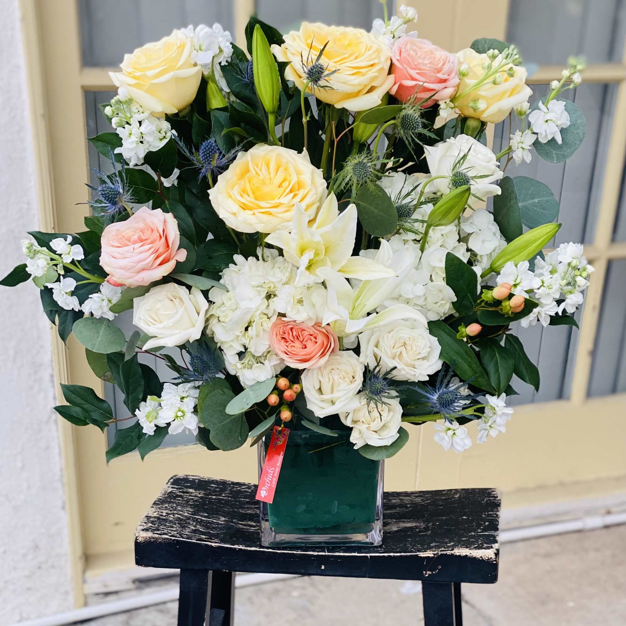 Bouquet of cream, pink, and white roses in a glass vase, photo 2 of 2