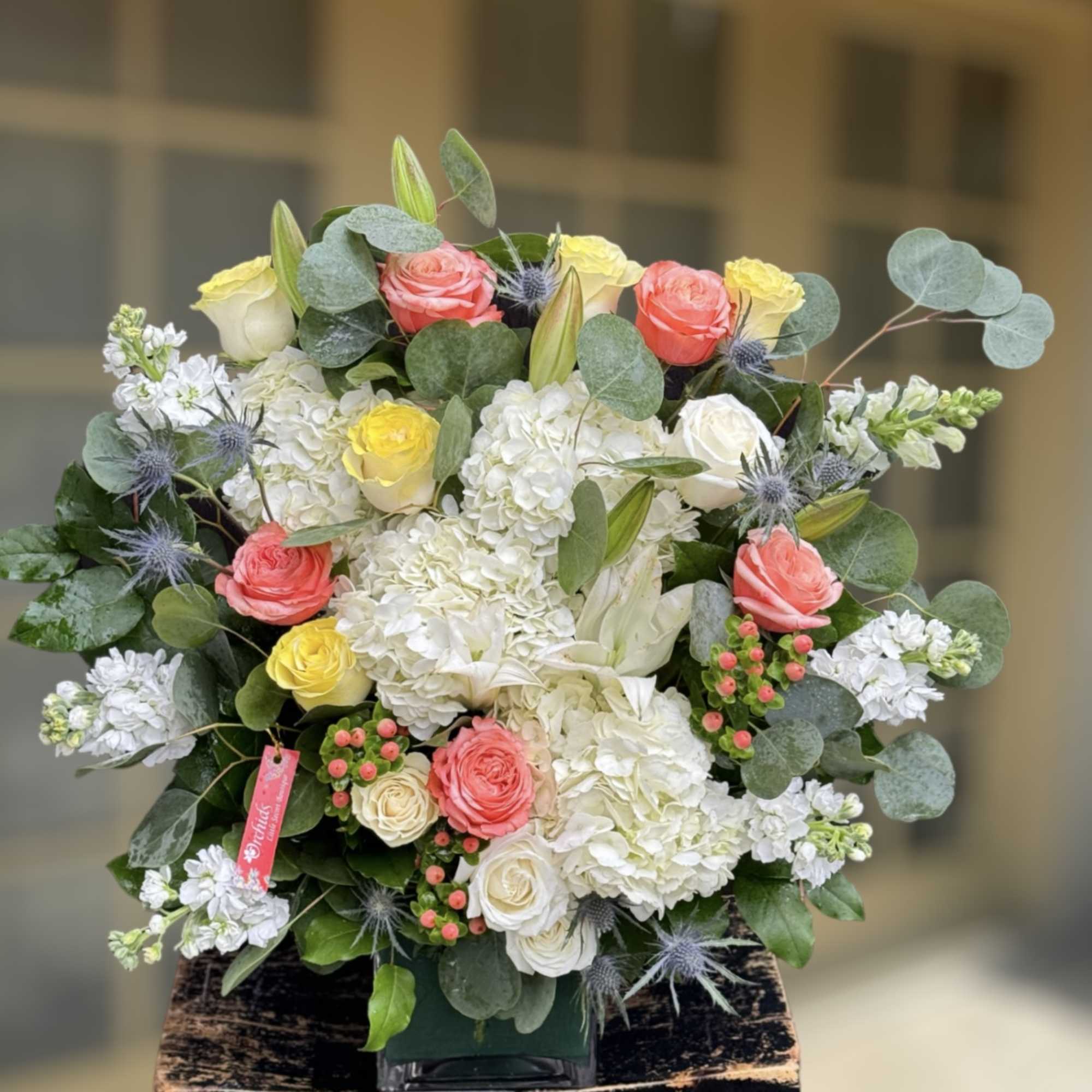 Mixed bouquet of roses, hydrangeas, and lilies in a vase
