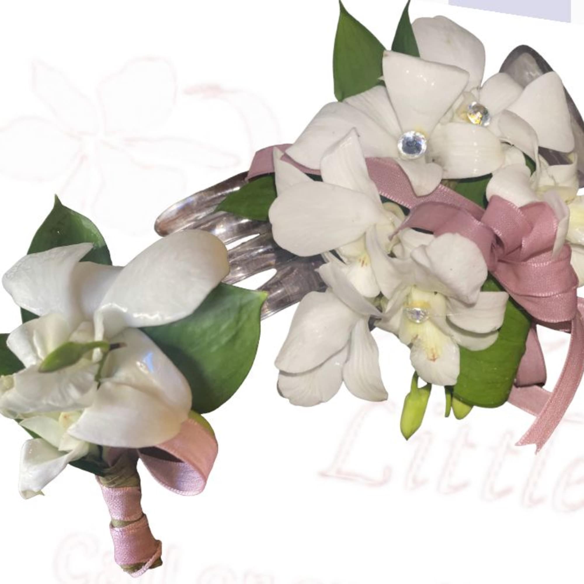 White floral wrist corsage and matching boutonniere with pink ribbon
