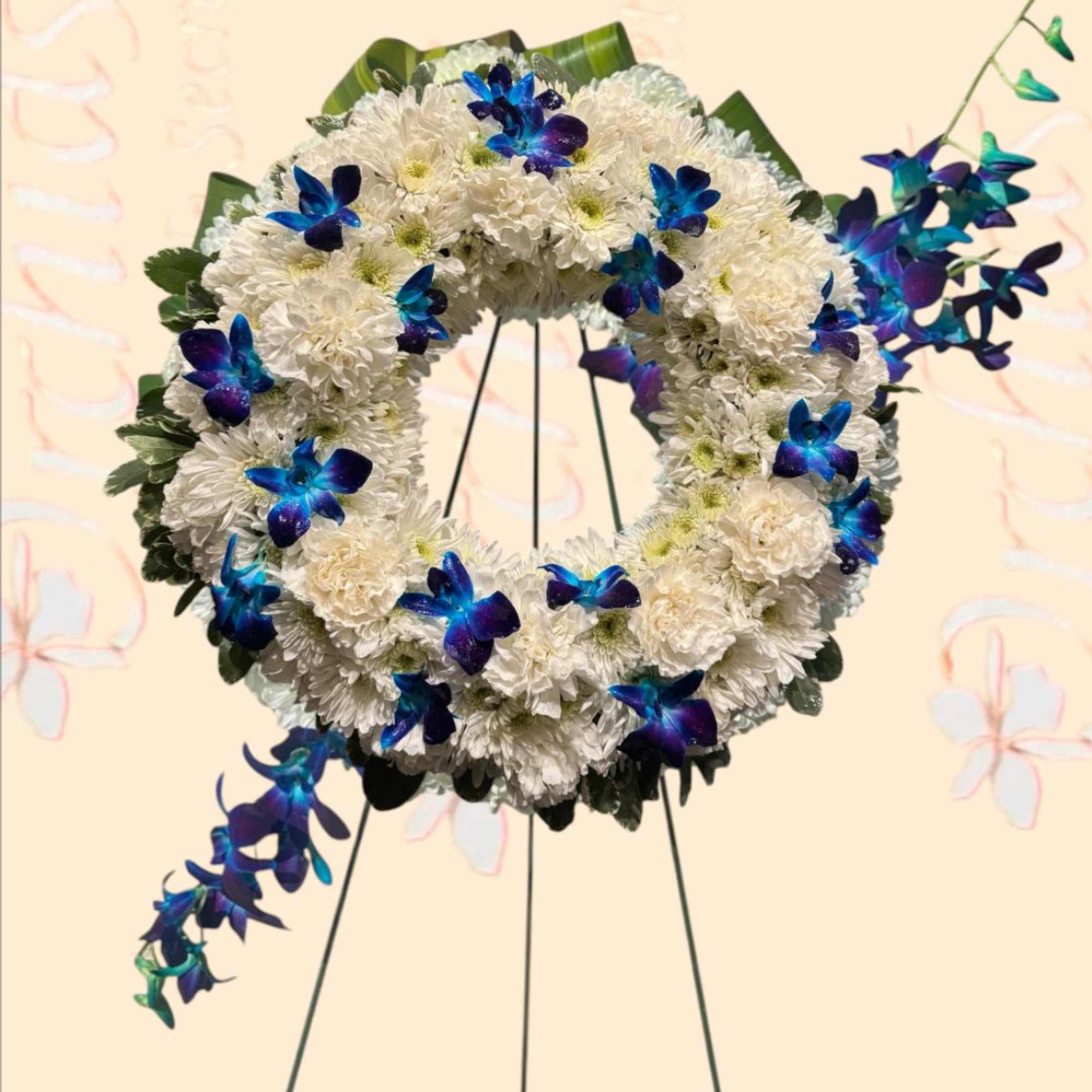 White floral wreath with blue-purple orchid accents on a stand