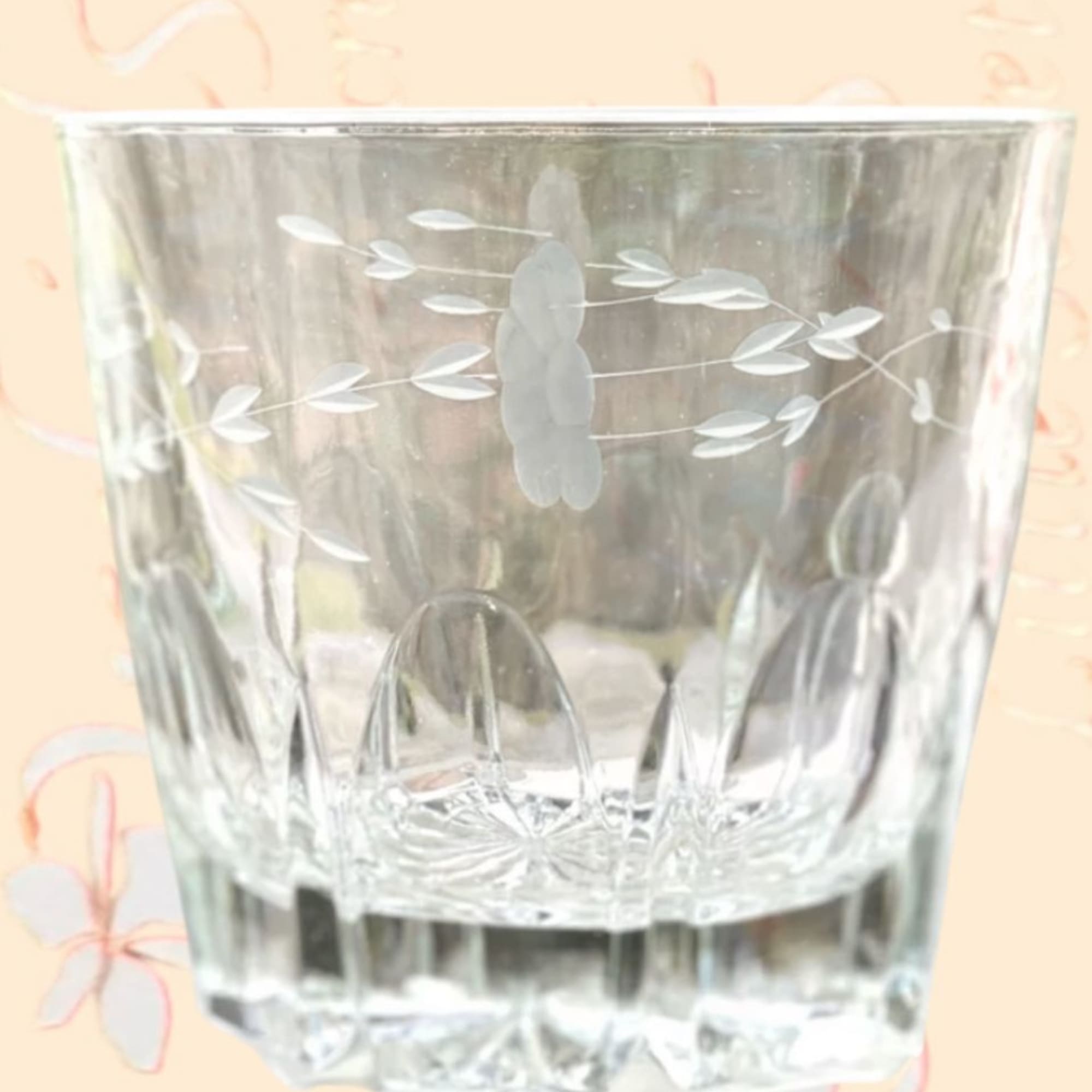 Clear etched glass tumbler with a floral pattern