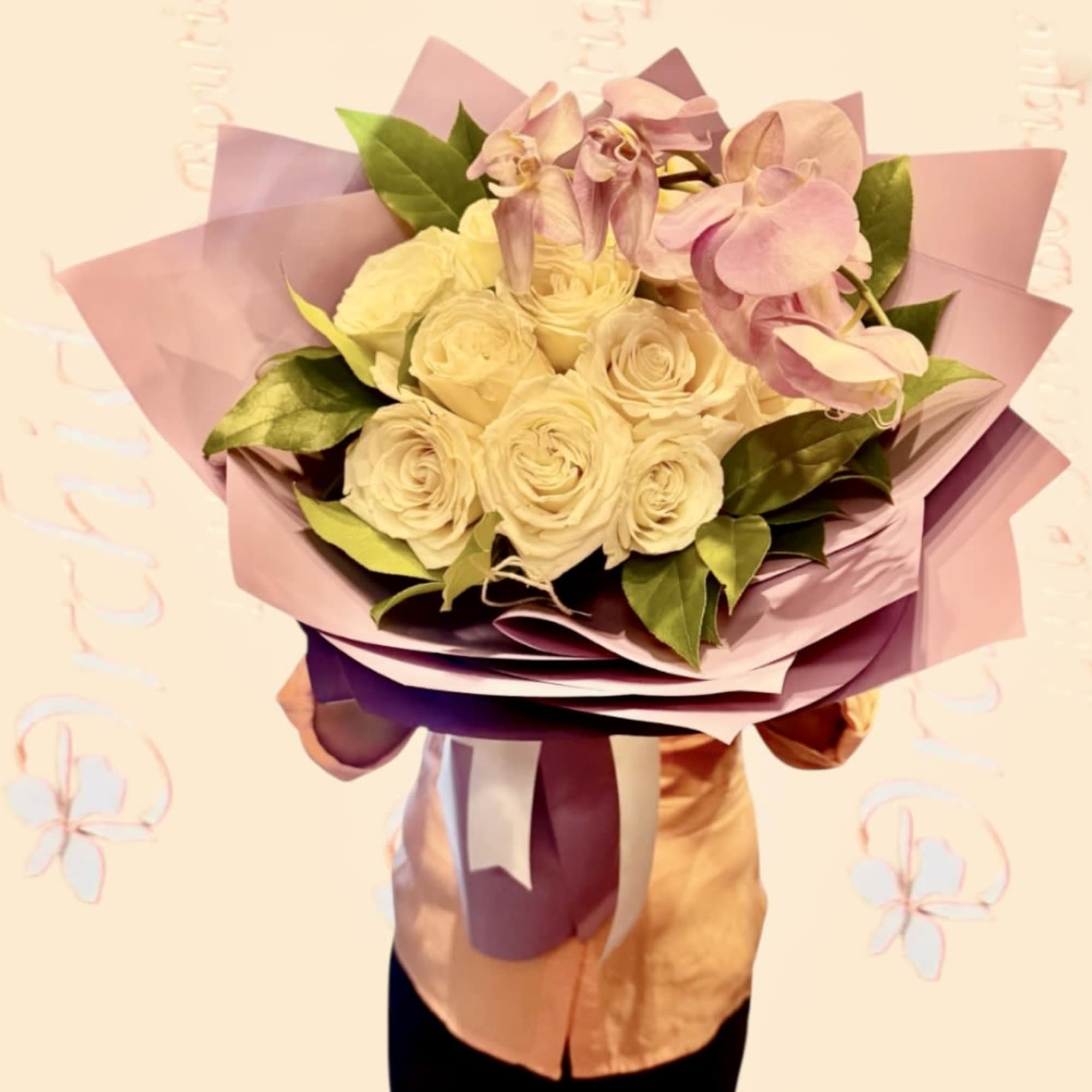 Bouquet of cream roses and pink orchids wrapped in pastel paper