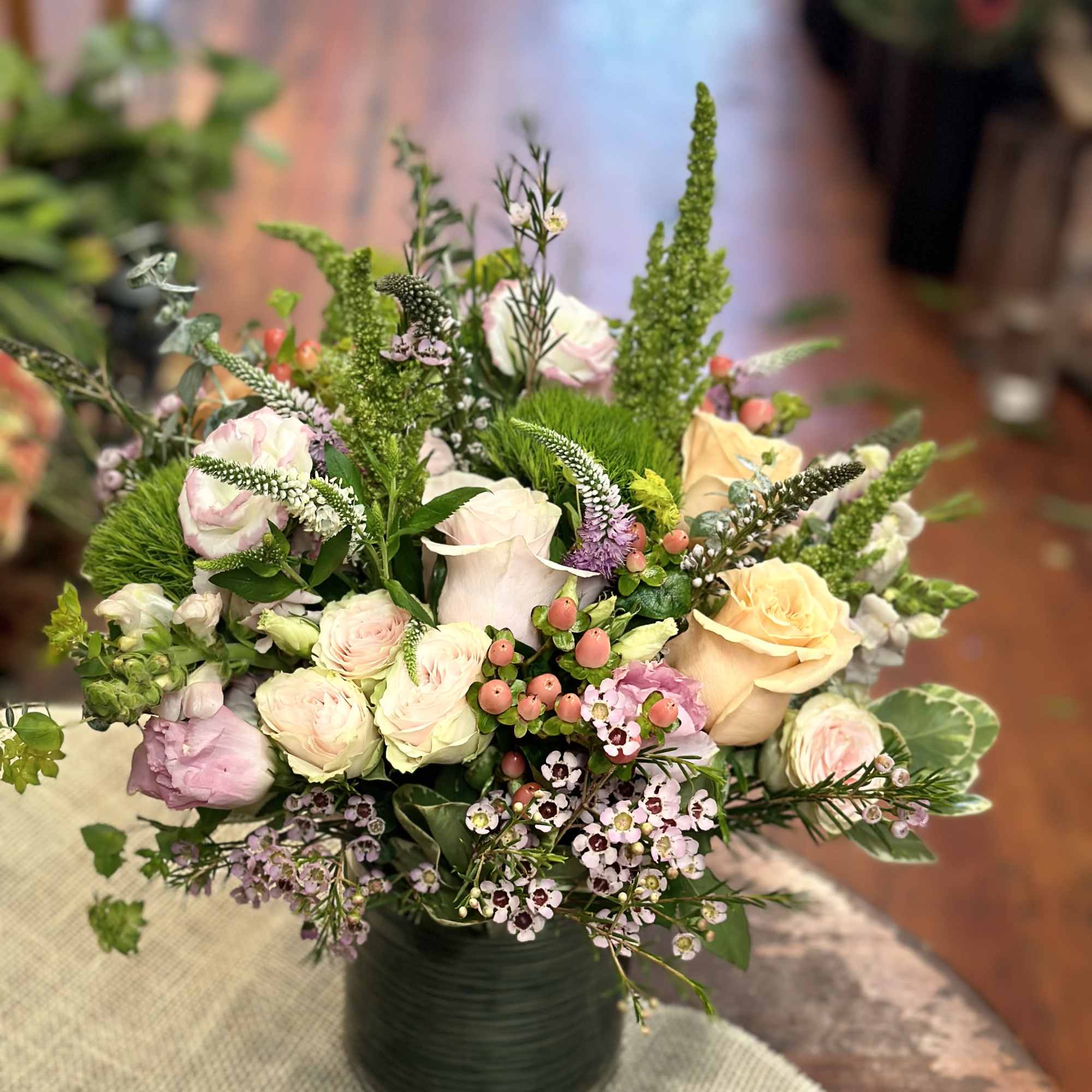 Mixed pastel bouquet in a dark green vase