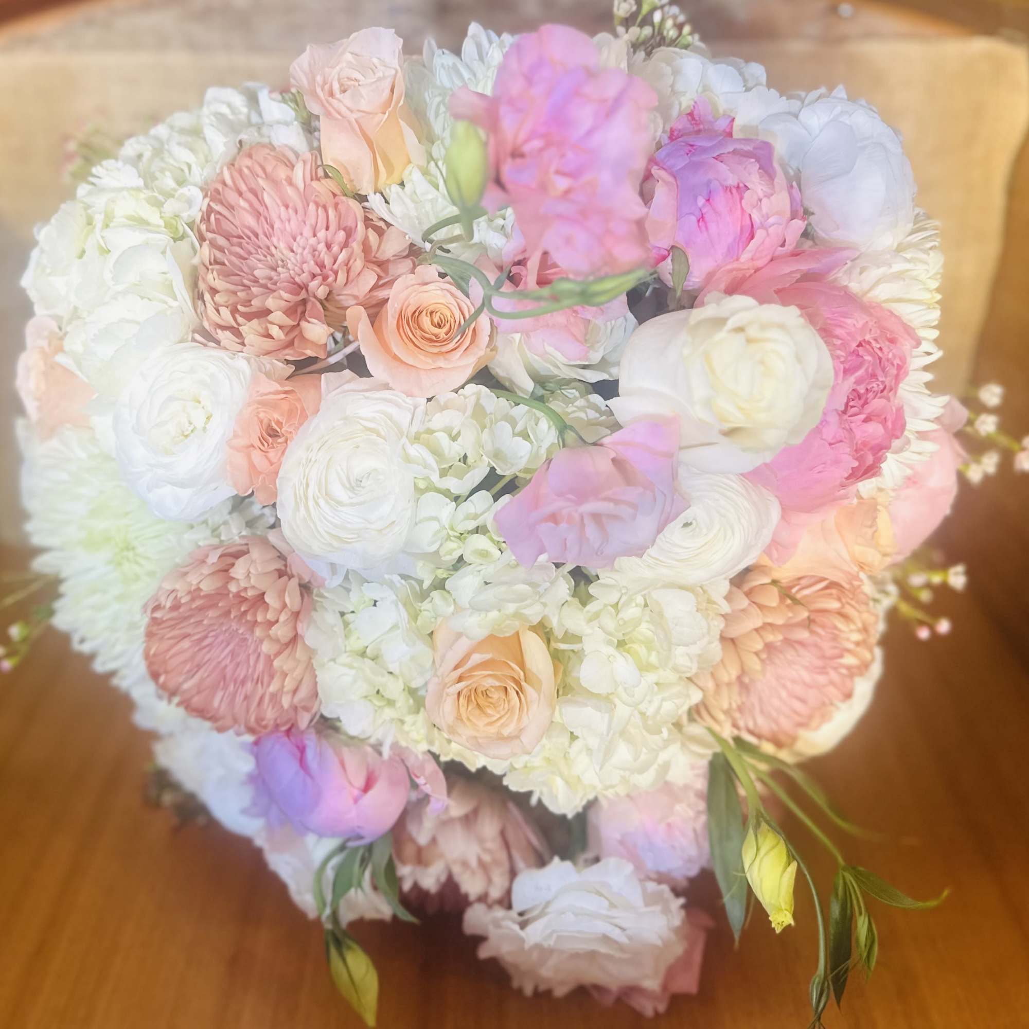 Bouquet of pink, peach, and white flowers on a wooden surface