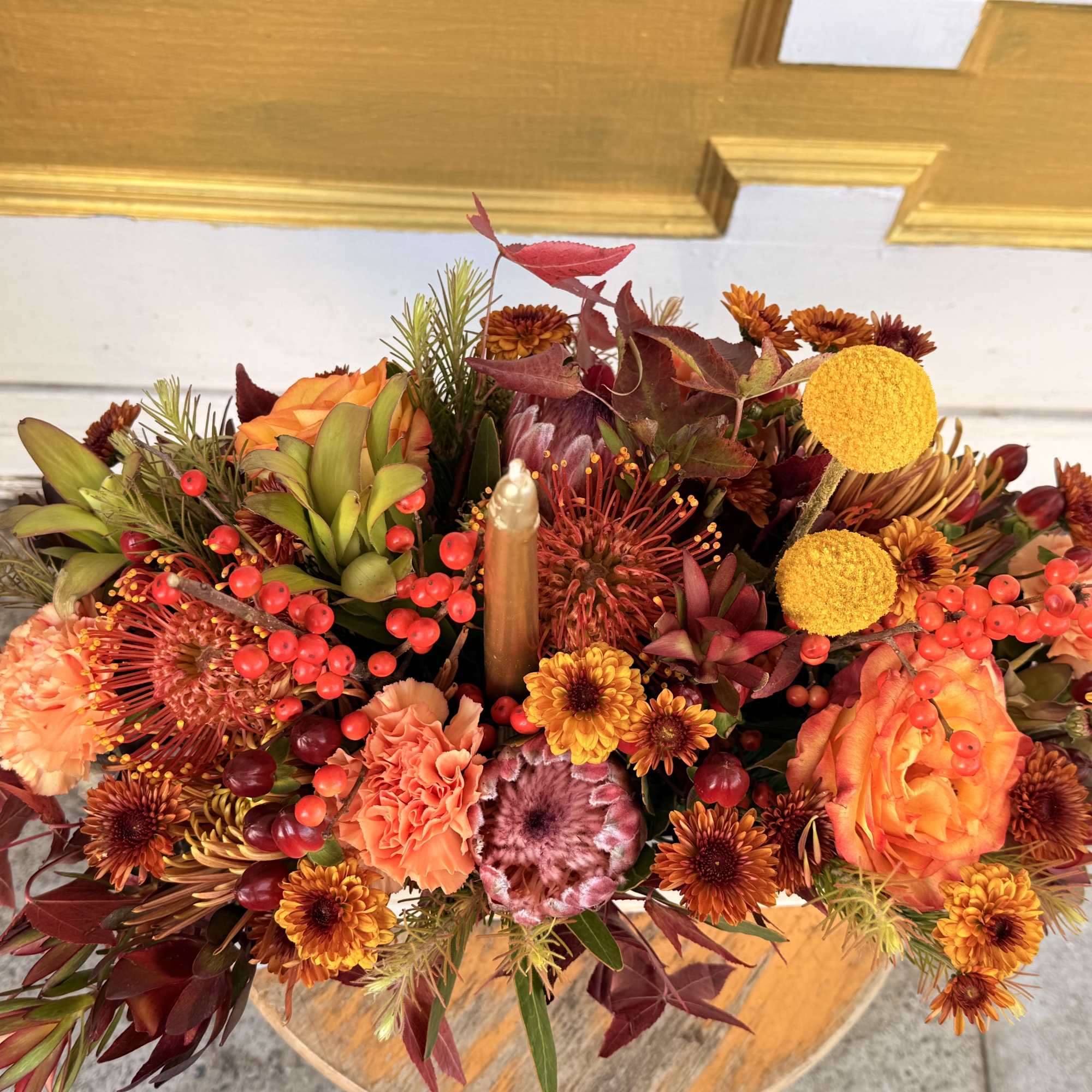 Autumn floral arrangement with orange and burgundy blooms in a vase