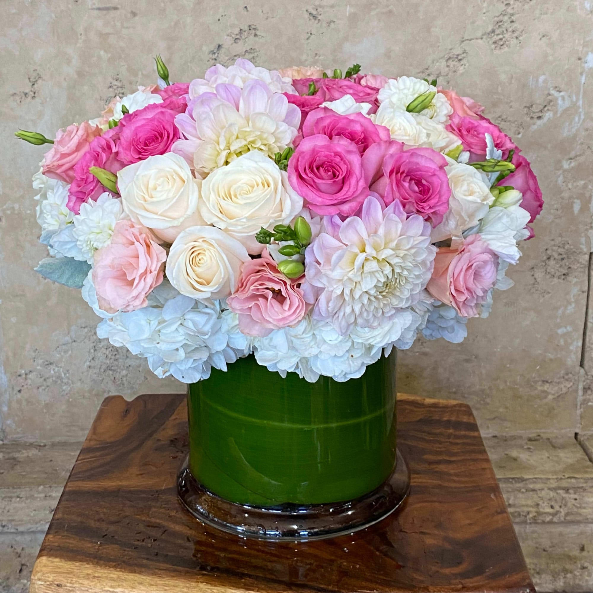 Pink and white rose bouquet with hydrangeas in a green vase
