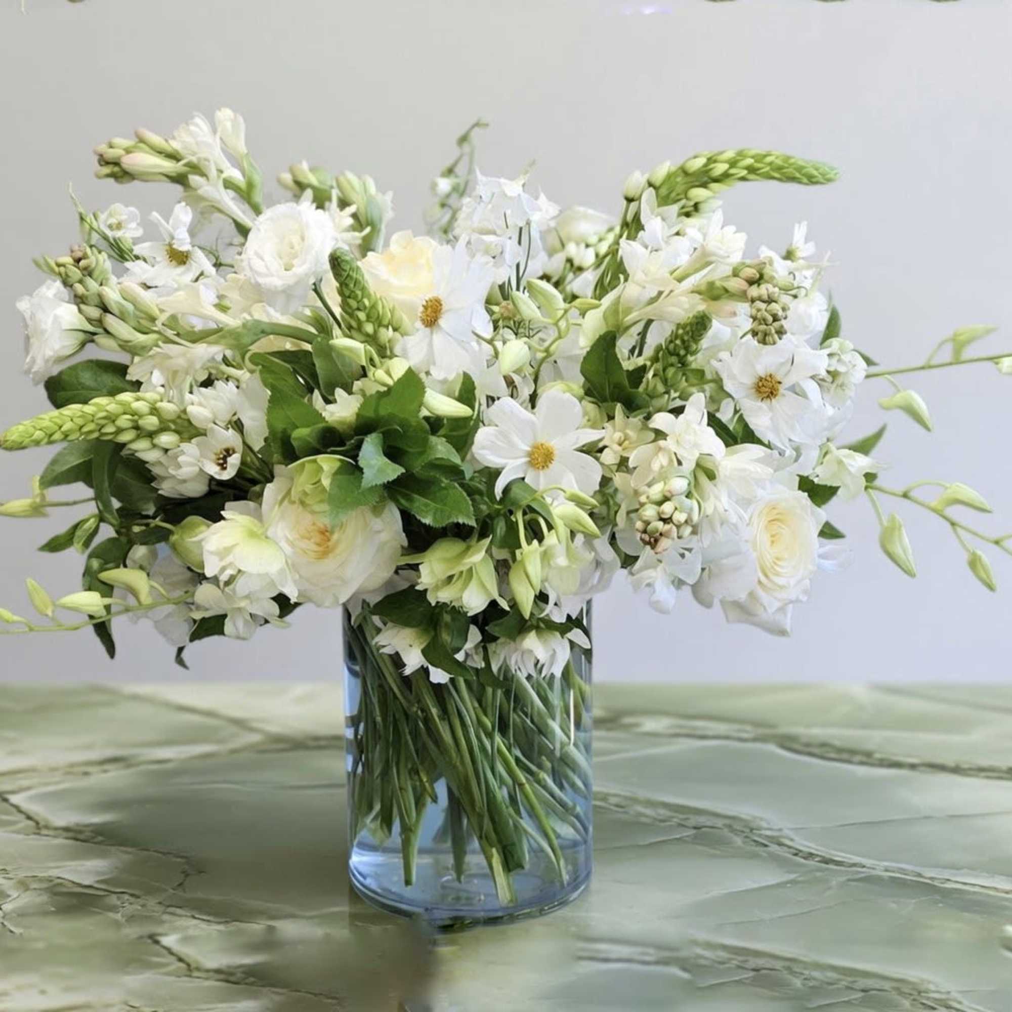 Lisianthus, Dahlias, Sweet Pea, and more white flower with greenery in glass