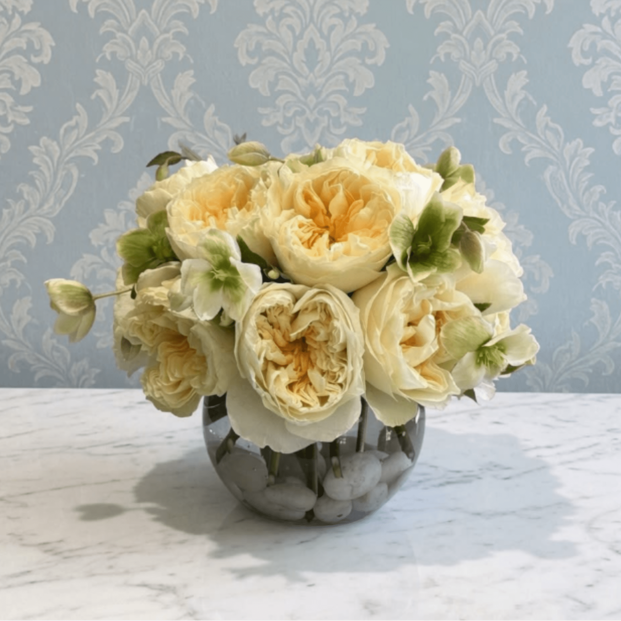This arrangement is the definition of understated luxury. Featuring creamy ivory garden