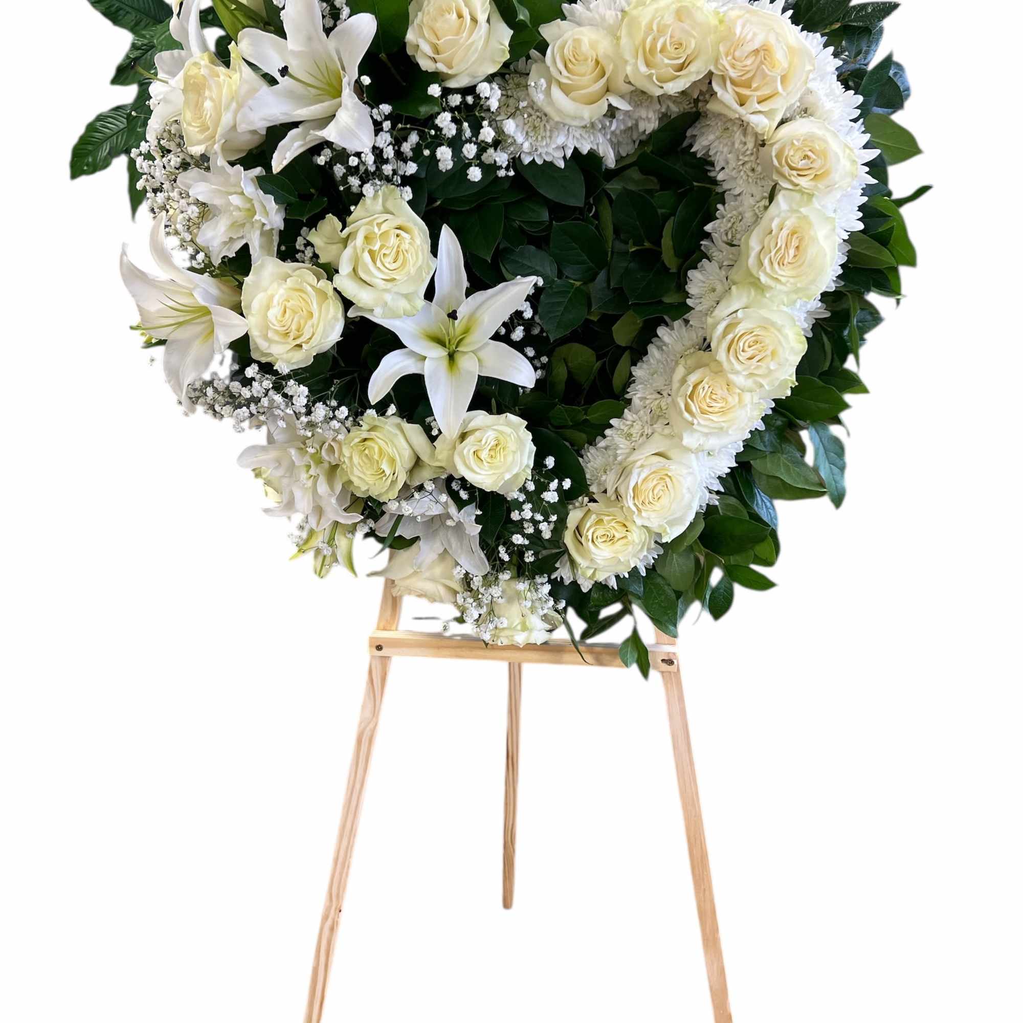 White roses, lilies, and baby's breath arranged in a heart shape with