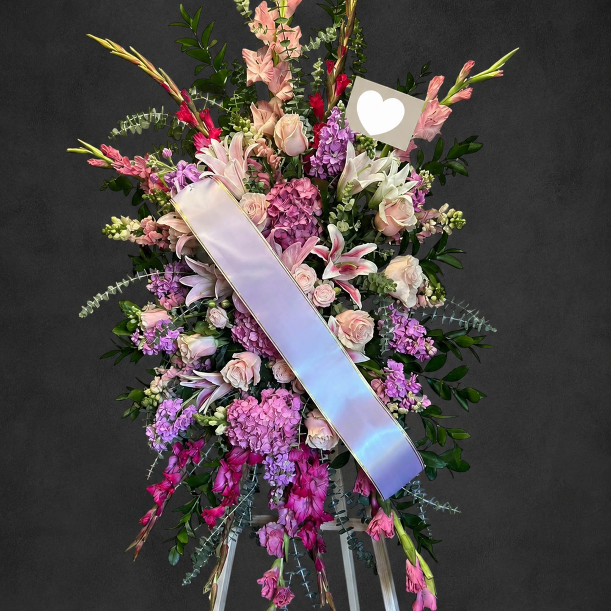 Standing floral spray with pink and purple flowers on an easel