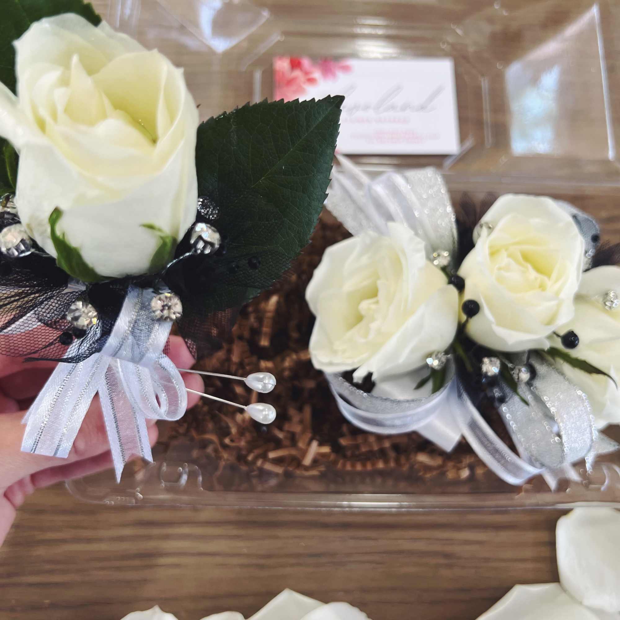 White rose corsages with silver ribbon and black tulle accents
