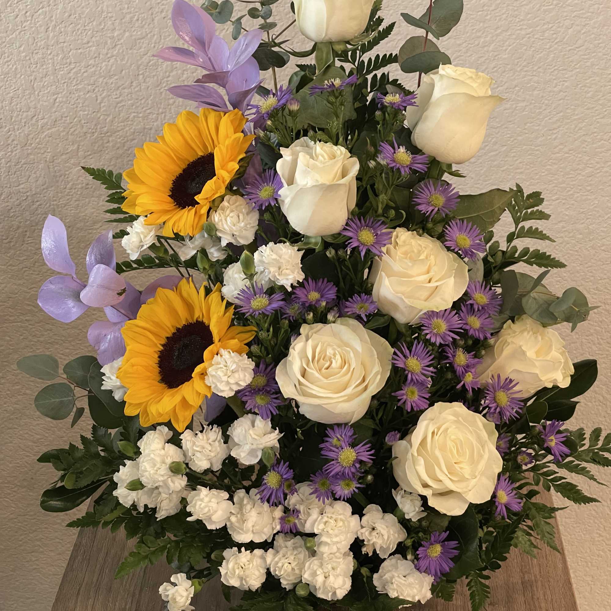 Cream-white roses paired with bold yellow sunflowers create a cheerful birthday bouquet