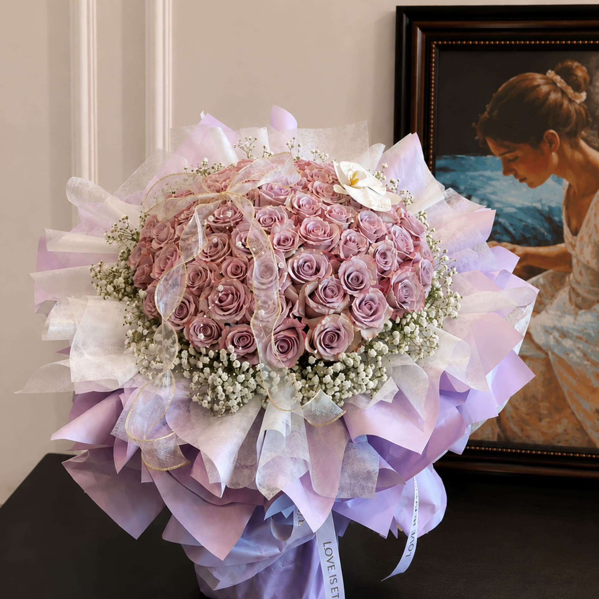 Large bouquet of pink roses wrapped in lavender and white paper