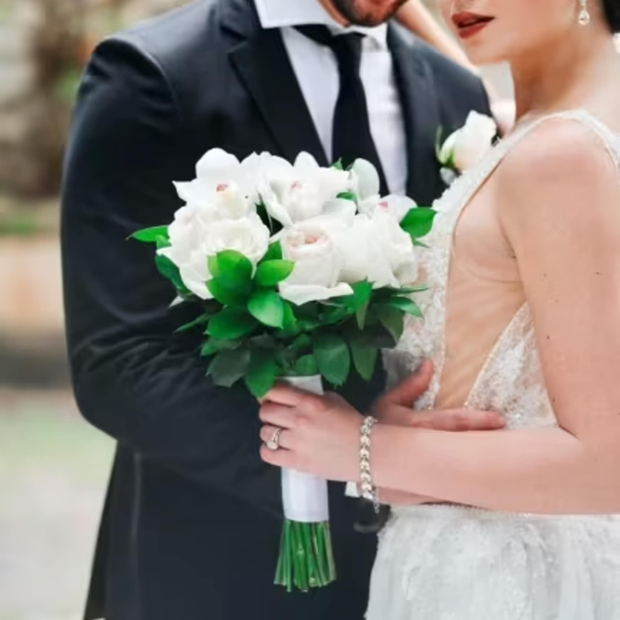 Bride and groom holding a white wedding bouquet