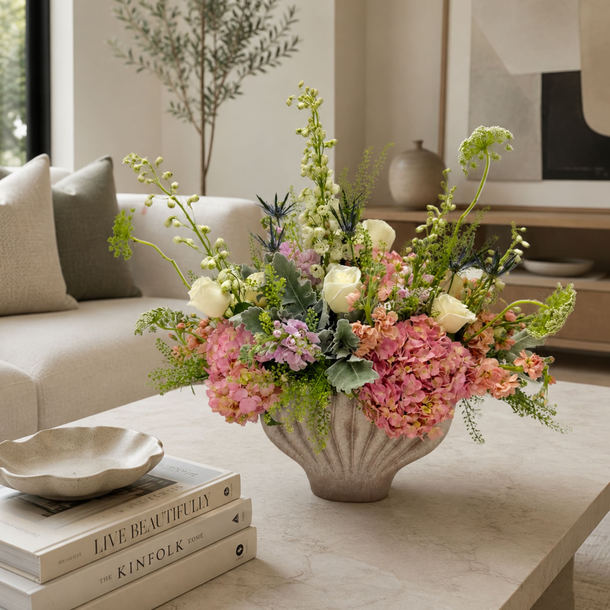 Pastel floral arrangement in a textured vase on a coffee table