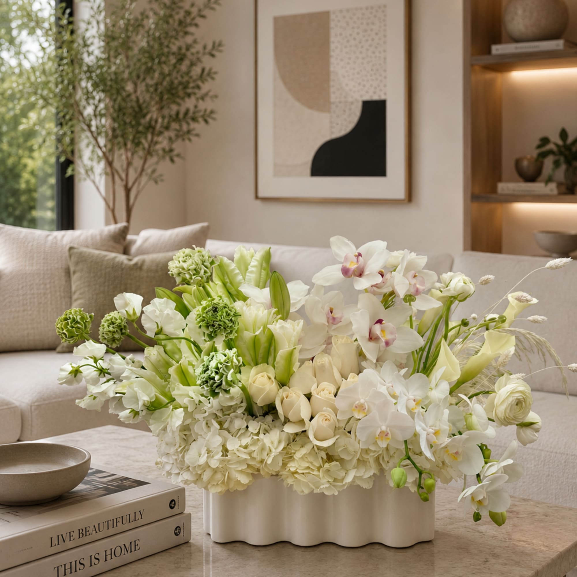 White and green floral arrangement in a low white vase on a coffee table