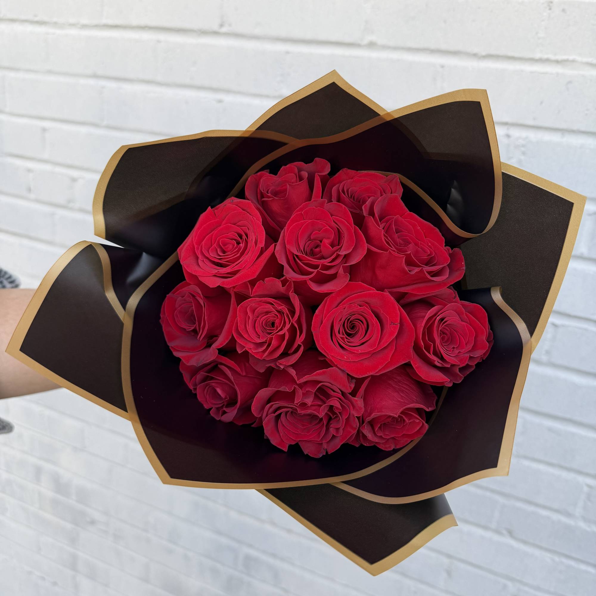 Bouquet of red roses wrapped in black and gold paper