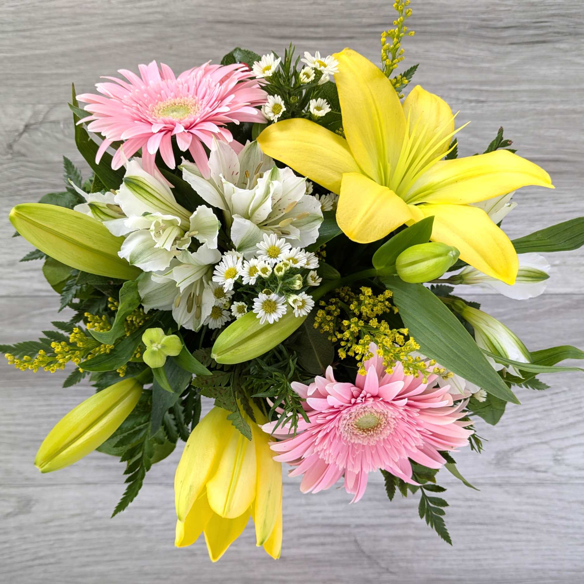 Bouquet with pink gerbera daisies, yellow lilies, and white alstroemeria