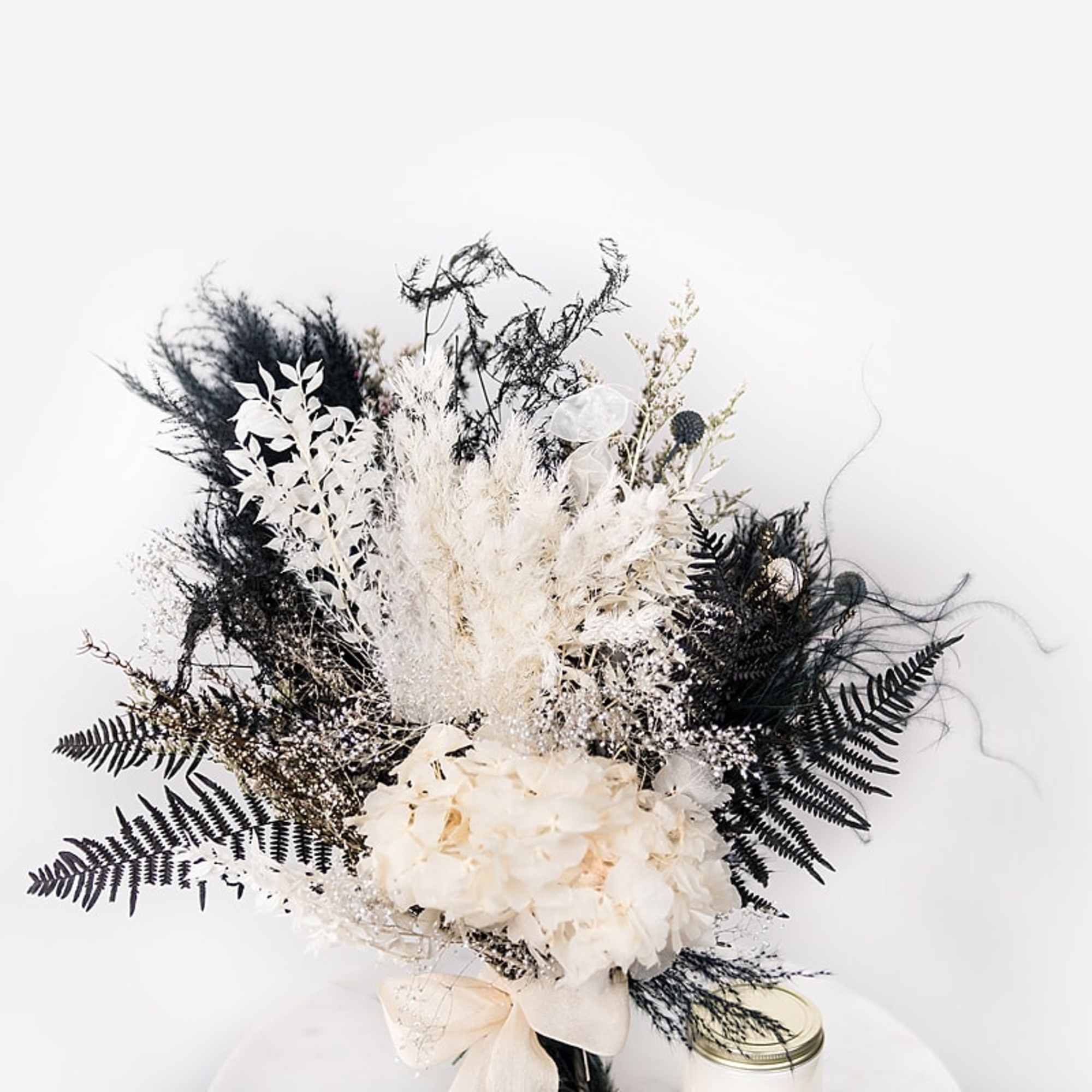 Black and white floral arrangement with hydrangeas and feathery foliage