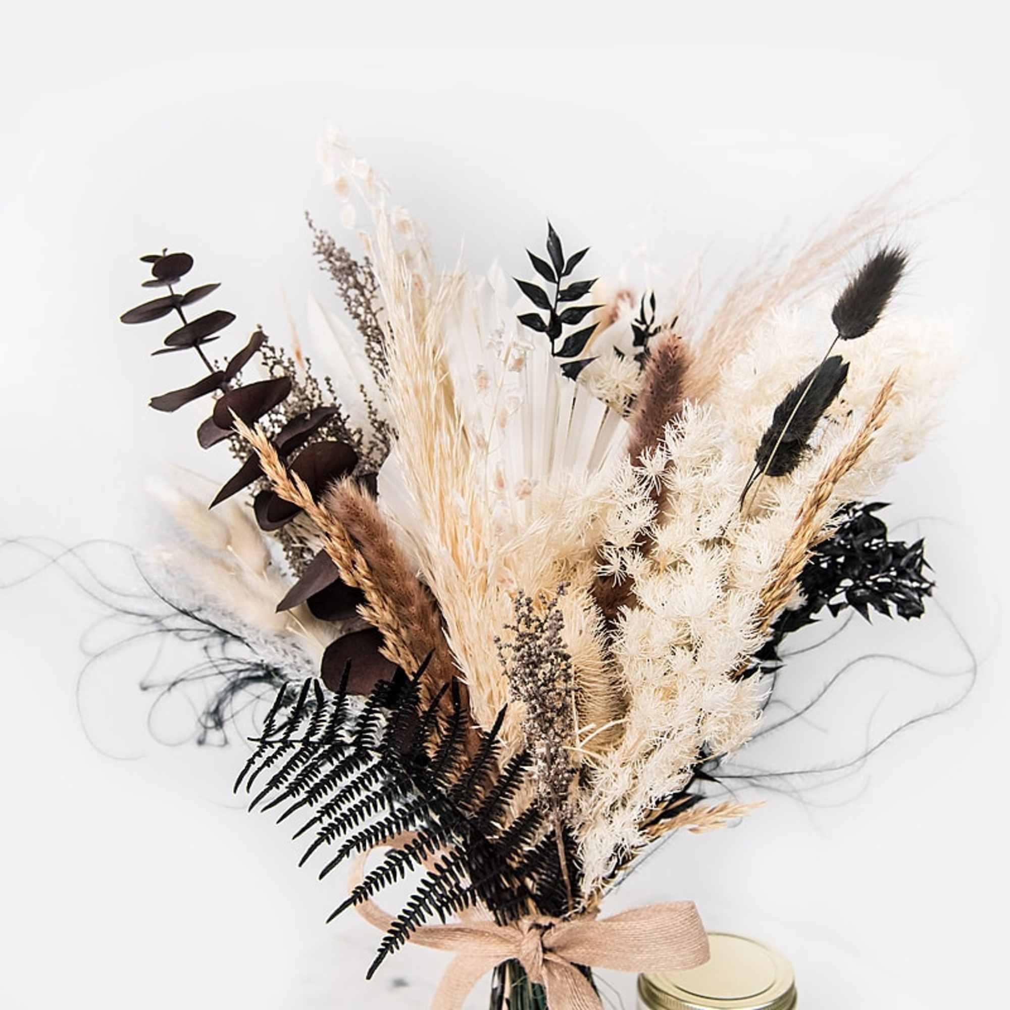 Dried floral bouquet with beige and black grasses tied with a ribbon