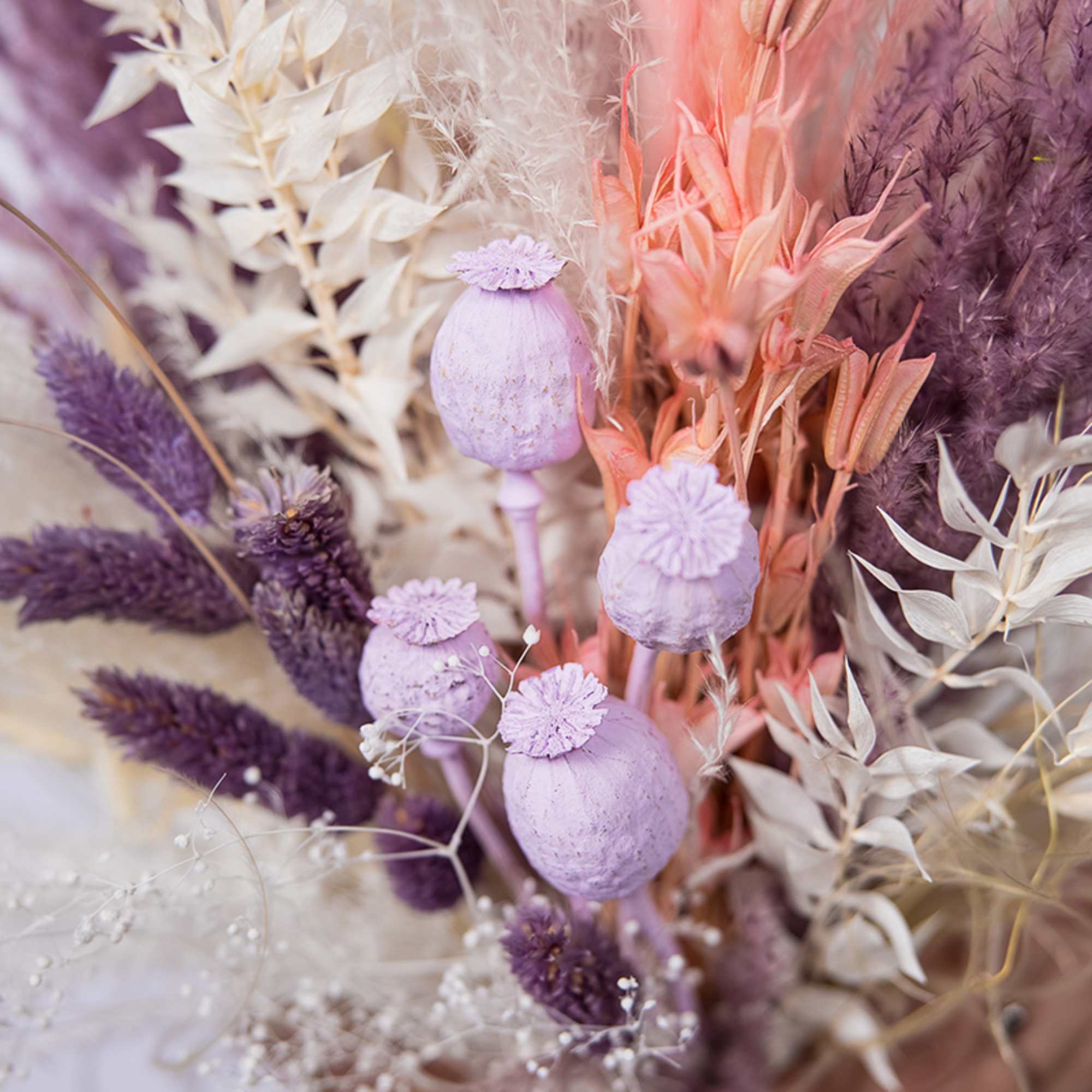 Dried floral arrangement with lavender poppy pods and purple grasses