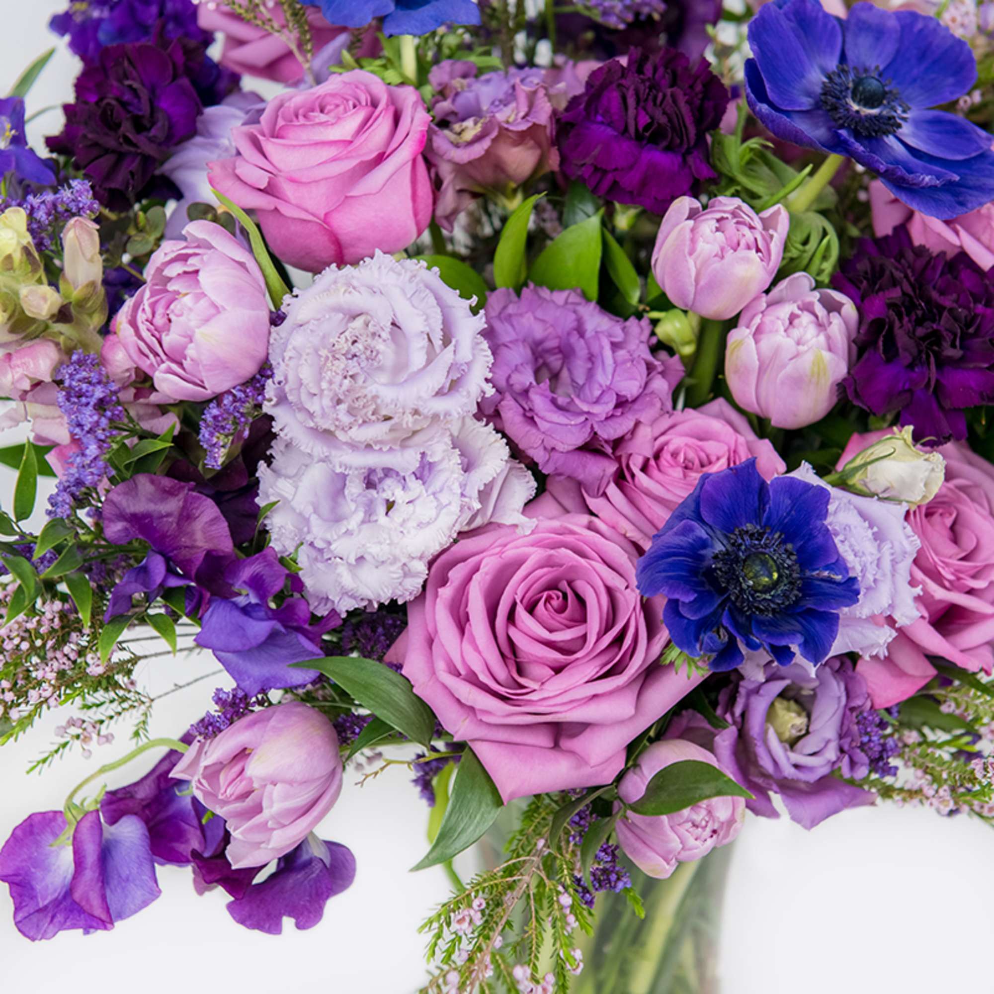 Pink and purple bouquet with roses, tulips, and blue anemones