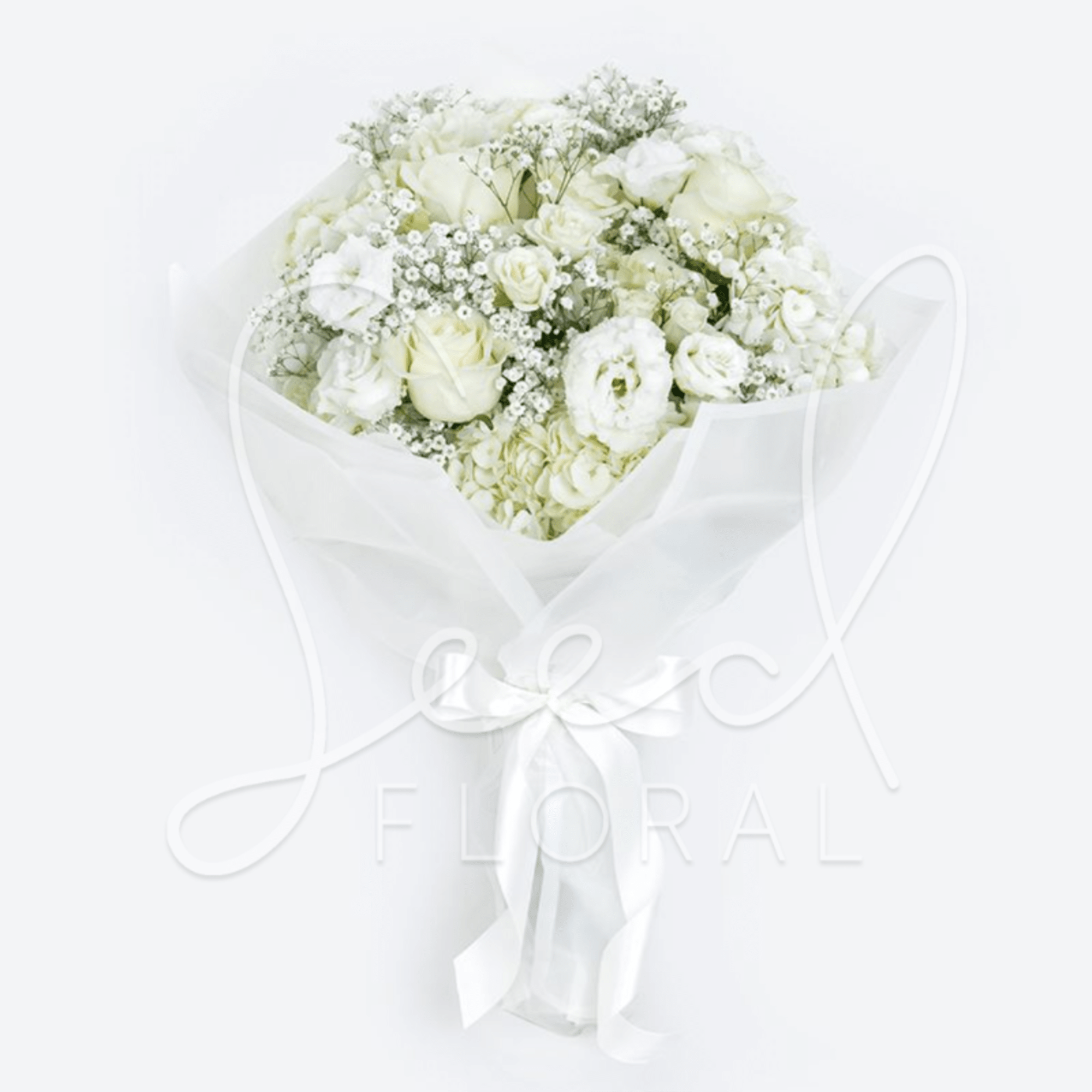 White bouquet of roses, lisianthus, hydrangeas, and baby's breath wrapped in white paper with a satin ribbon