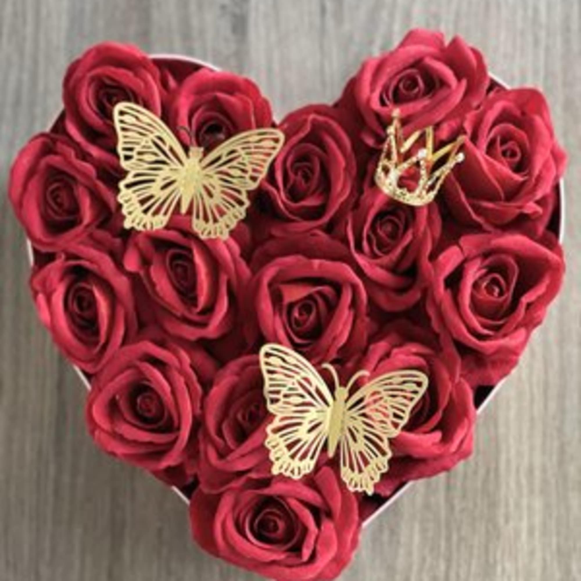 Heart-shaped box of red roses with gold butterfly accents