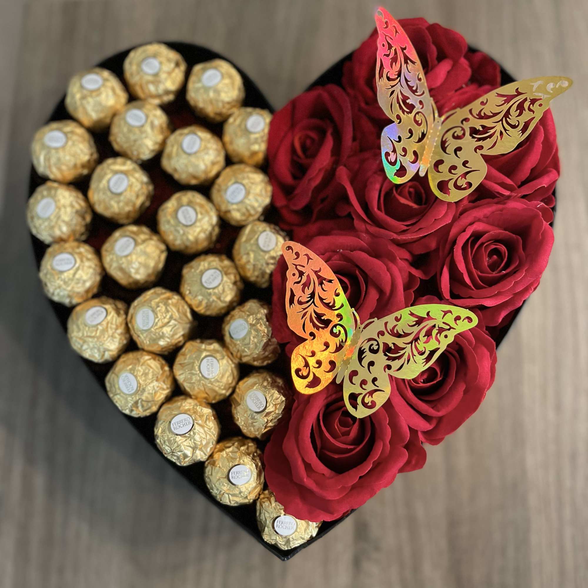 Heart-shaped box with red roses and gold-wrapped chocolates