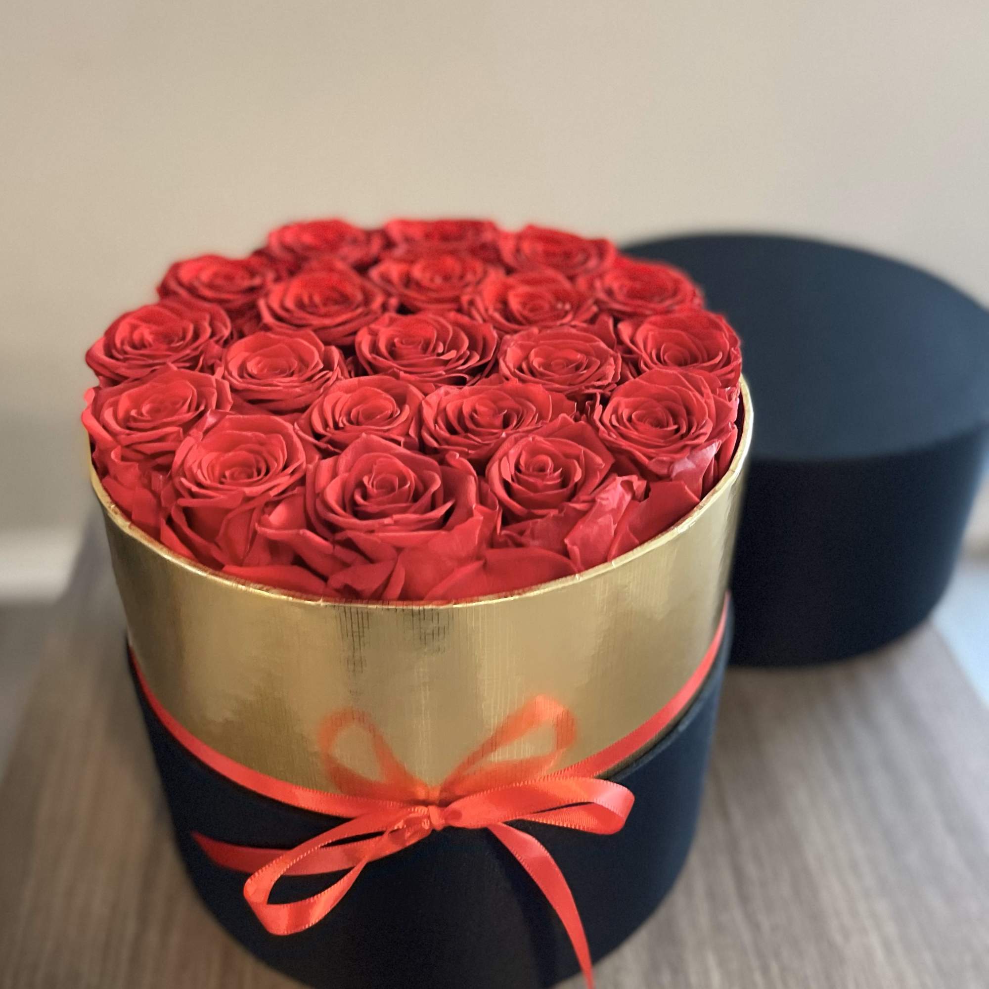 Round box of red roses tied with a ribbon