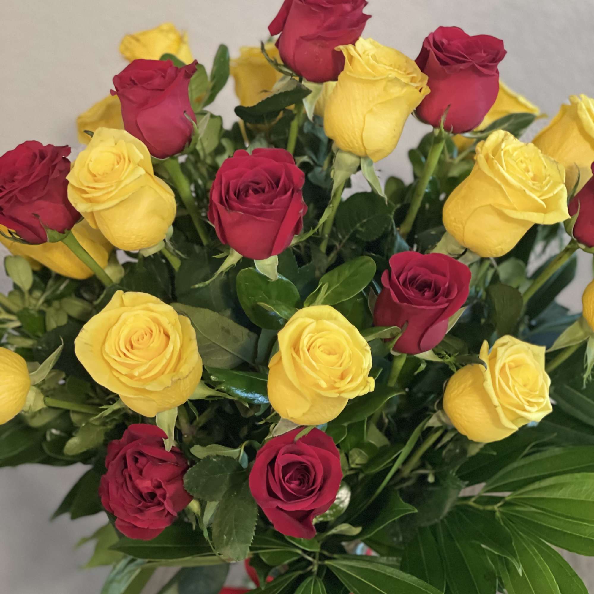 Bouquet of red and yellow roses with greenery