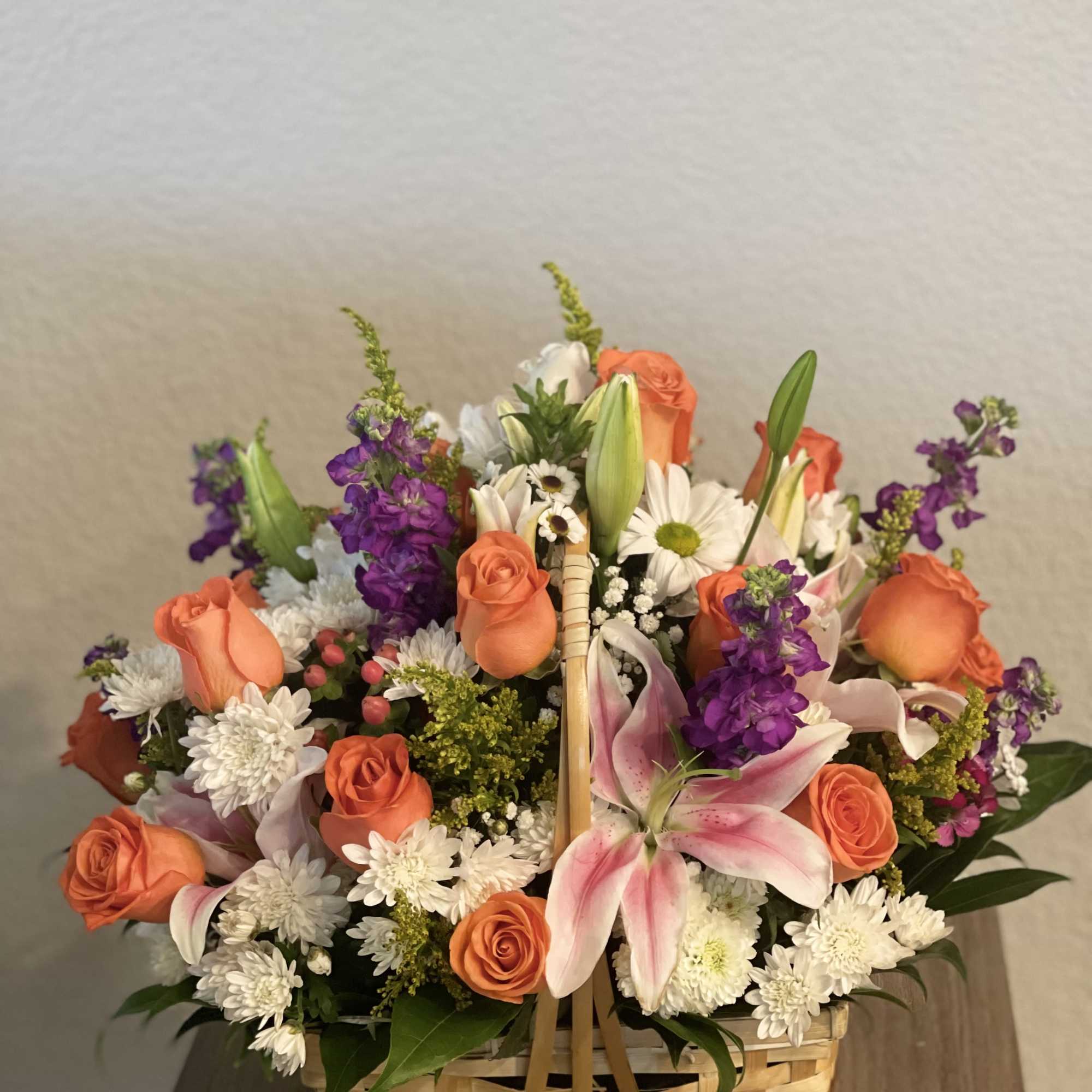 Basket arrangement of orange roses, pink lilies, and white daisies, photo 2 of 2